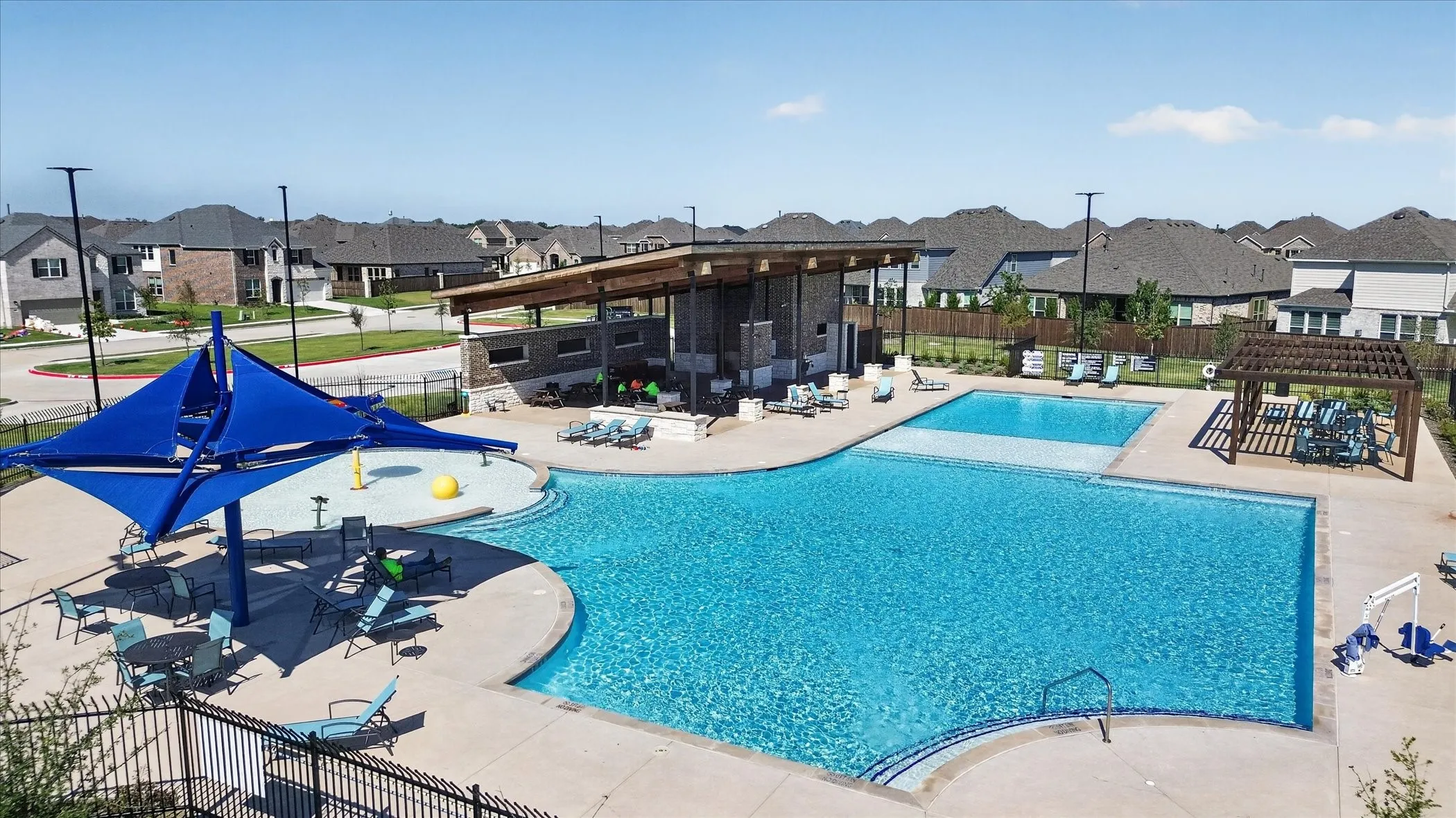 Community swimming pool featuring multiple depths and a shallow splash pad