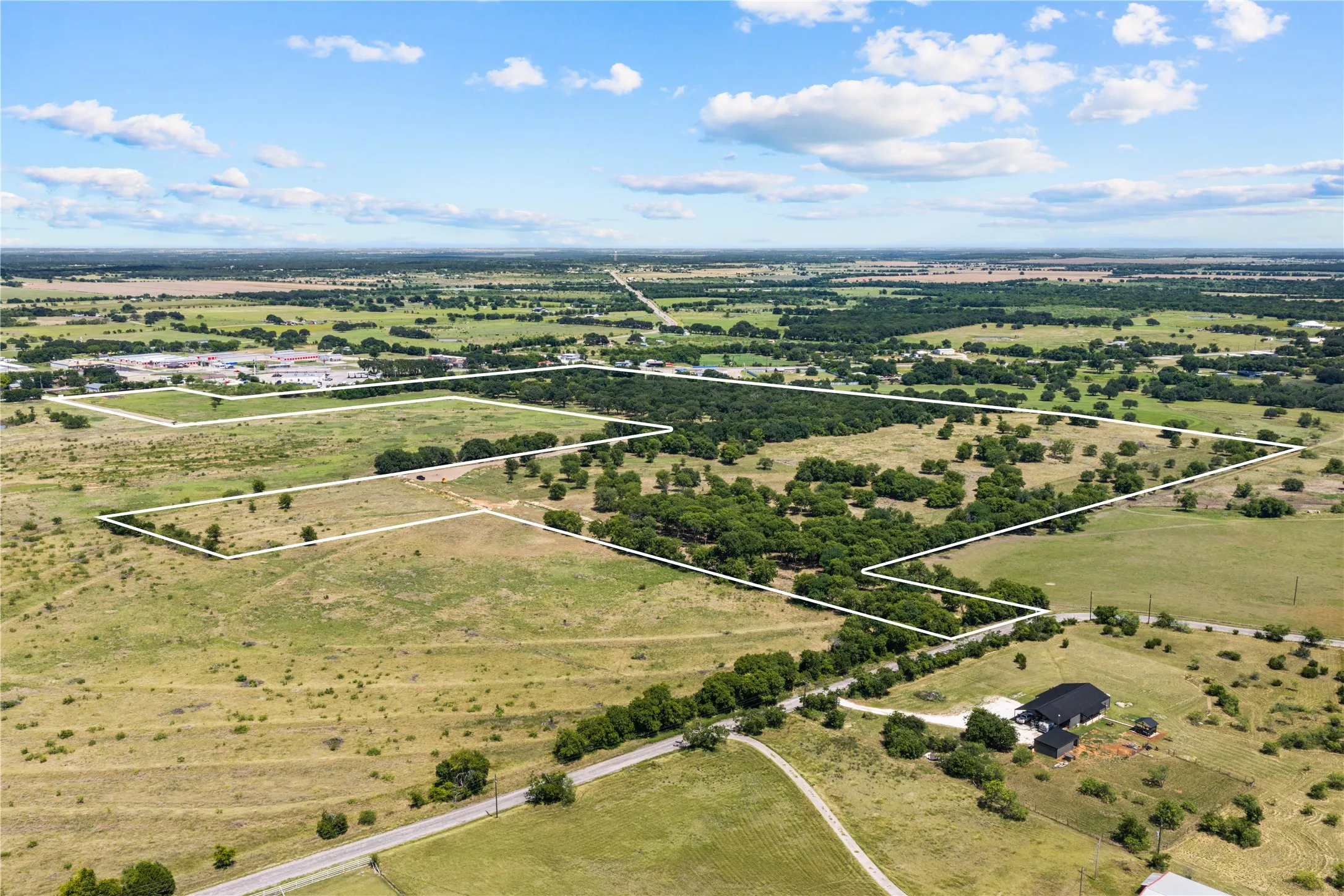 Expansive rural land with marked property lines, open fields, and scattered mature trees