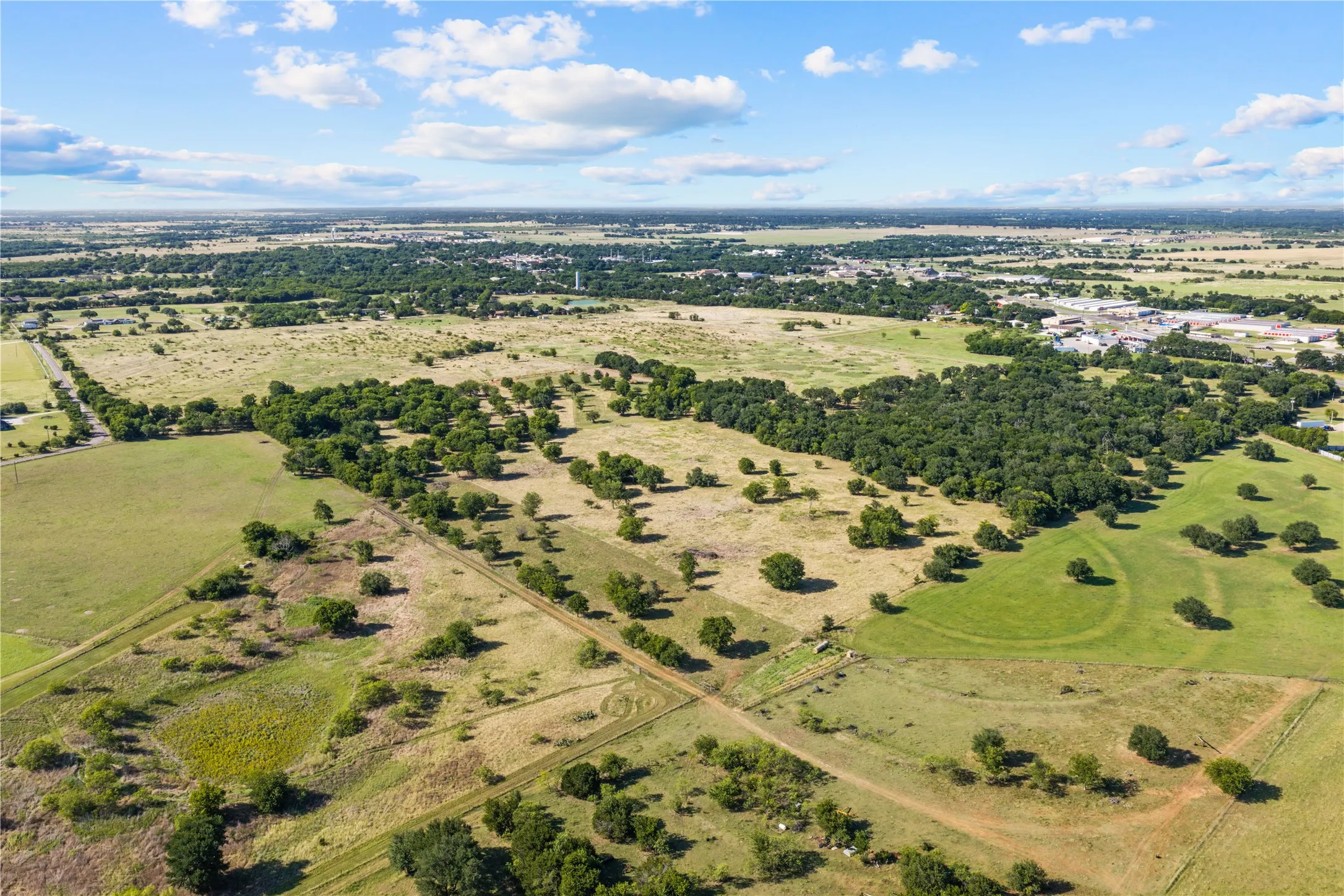 Expansive land featuring mature trees and varied terrain