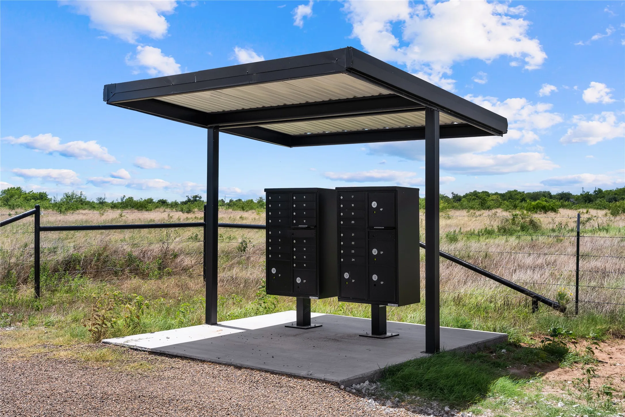 Covered mailboxes with a metal roof on a concrete pad