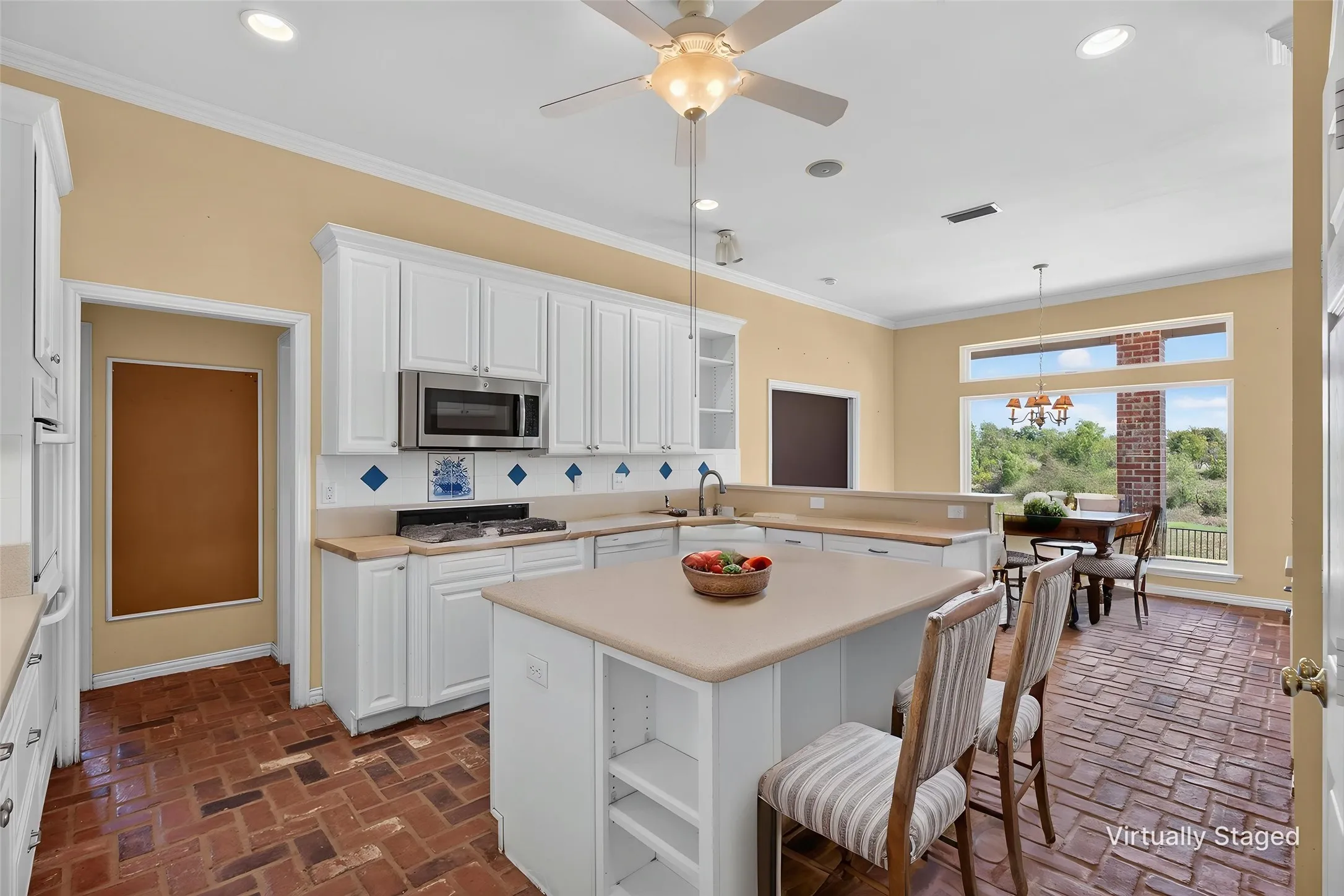 The heart of the home is a kitchen that simply delights, with abundant cabinetry and counter space, a five-burner gas stovetop, double oven, a generous eat-at island perfect for morning coffee or lingering conversation, and a gorgeous Italian tile backsplash that ties it all together.