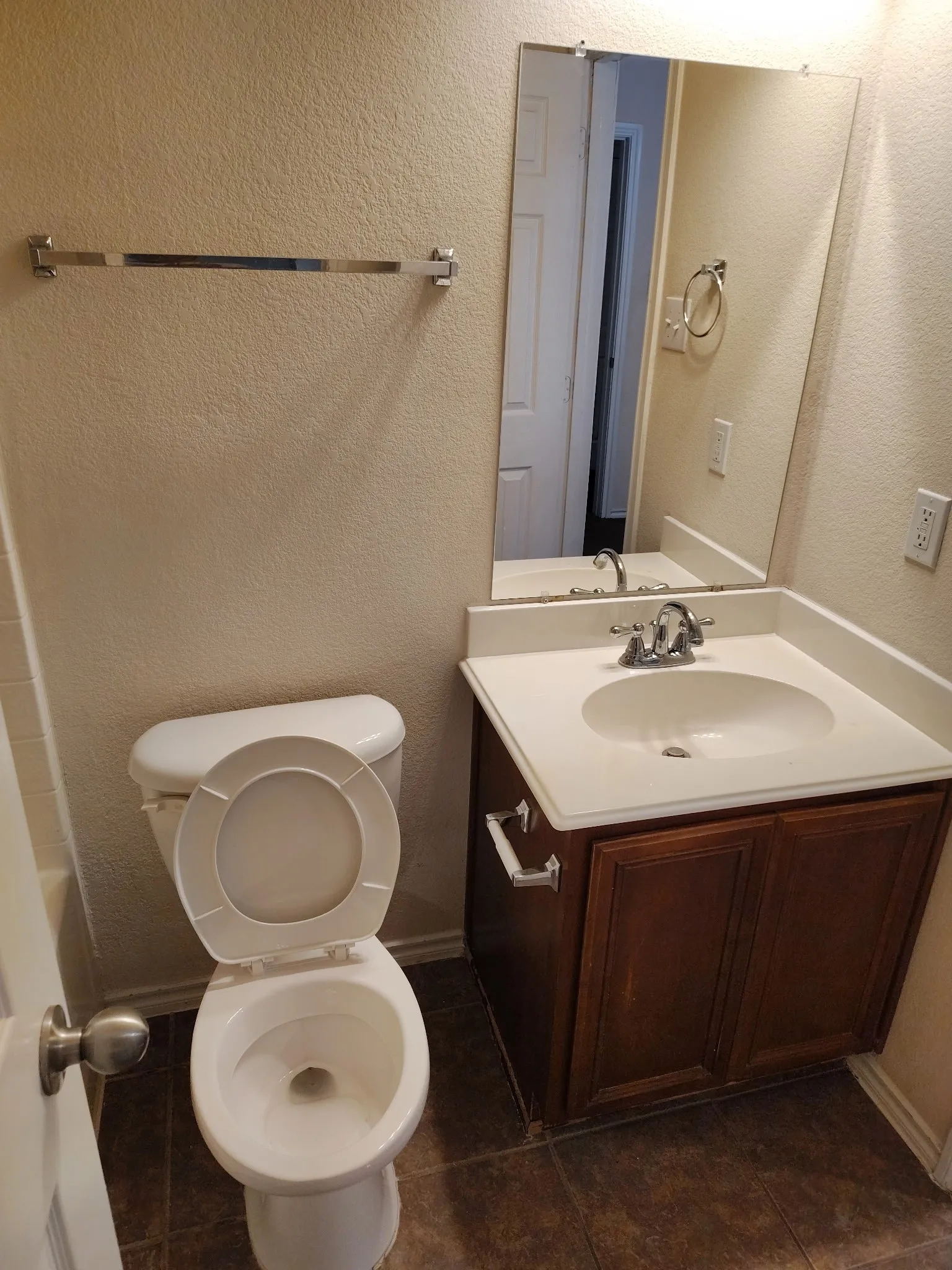 Vanity with wood-finish cabinetry, integrated sink, and laminate countertop