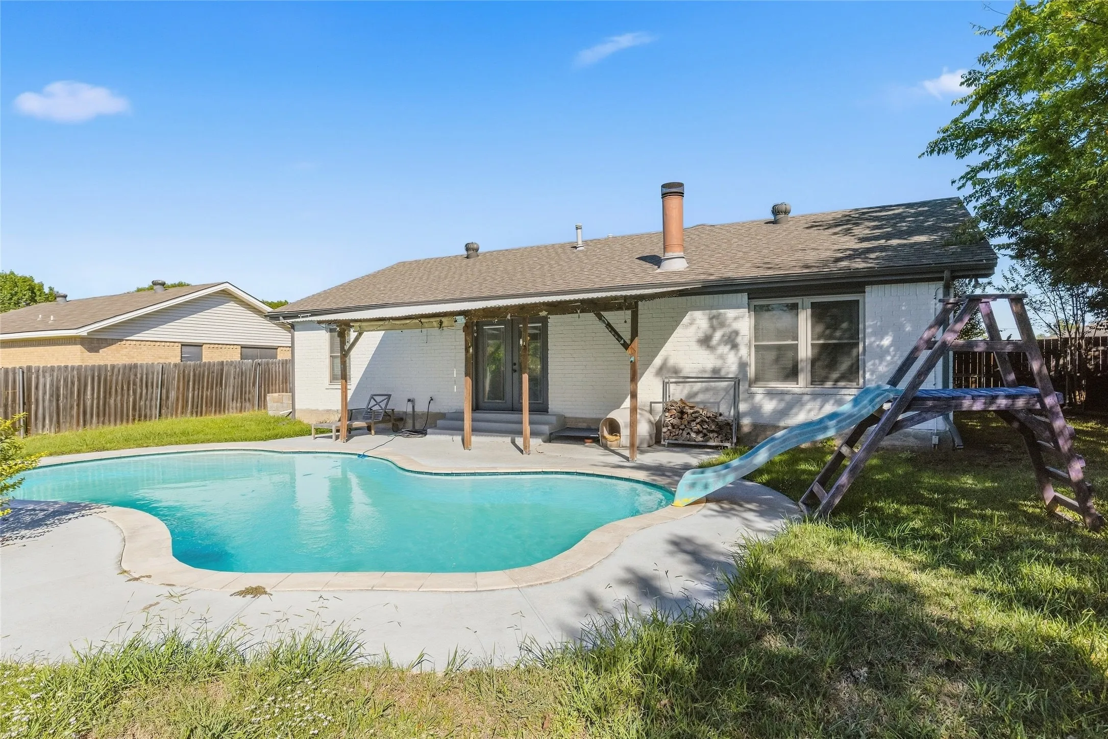 In-ground swimming pool with concrete surround