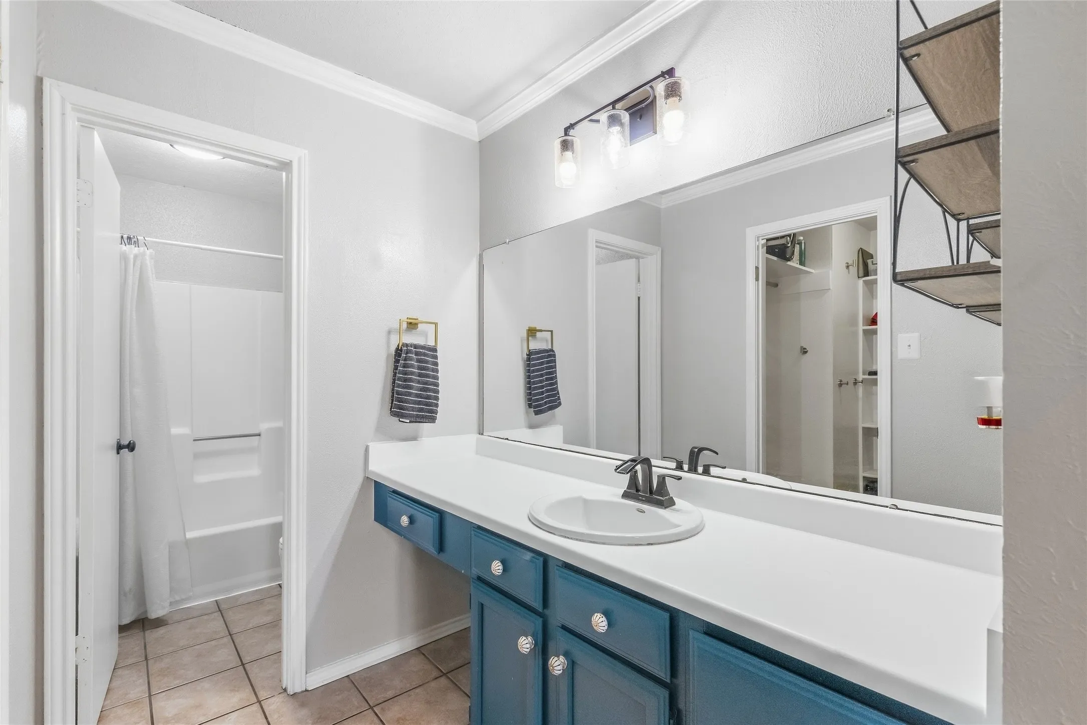 Vanity with integrated sink, white countertop, and teal cabinetry