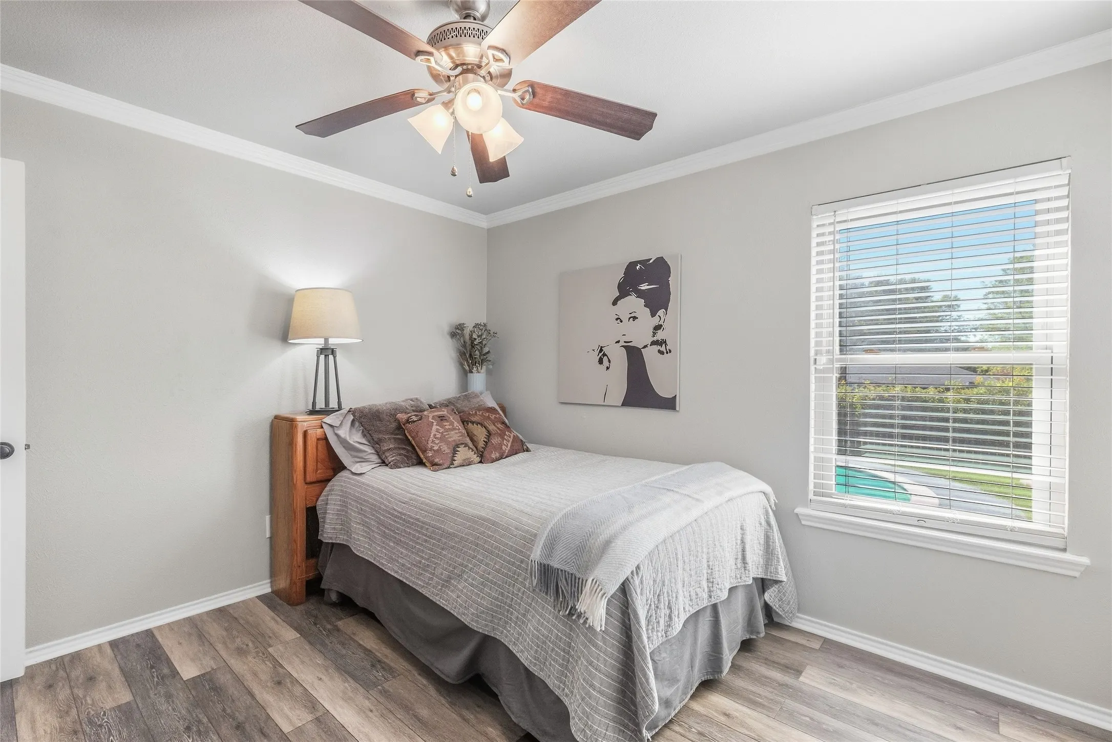 Wood-finish flooring, crown molding, and a ceiling fan with integrated​​‌​​​​‌​​‌‌​‌‌​​​‌‌​‌​‌​‌​​​‌​​ lighting