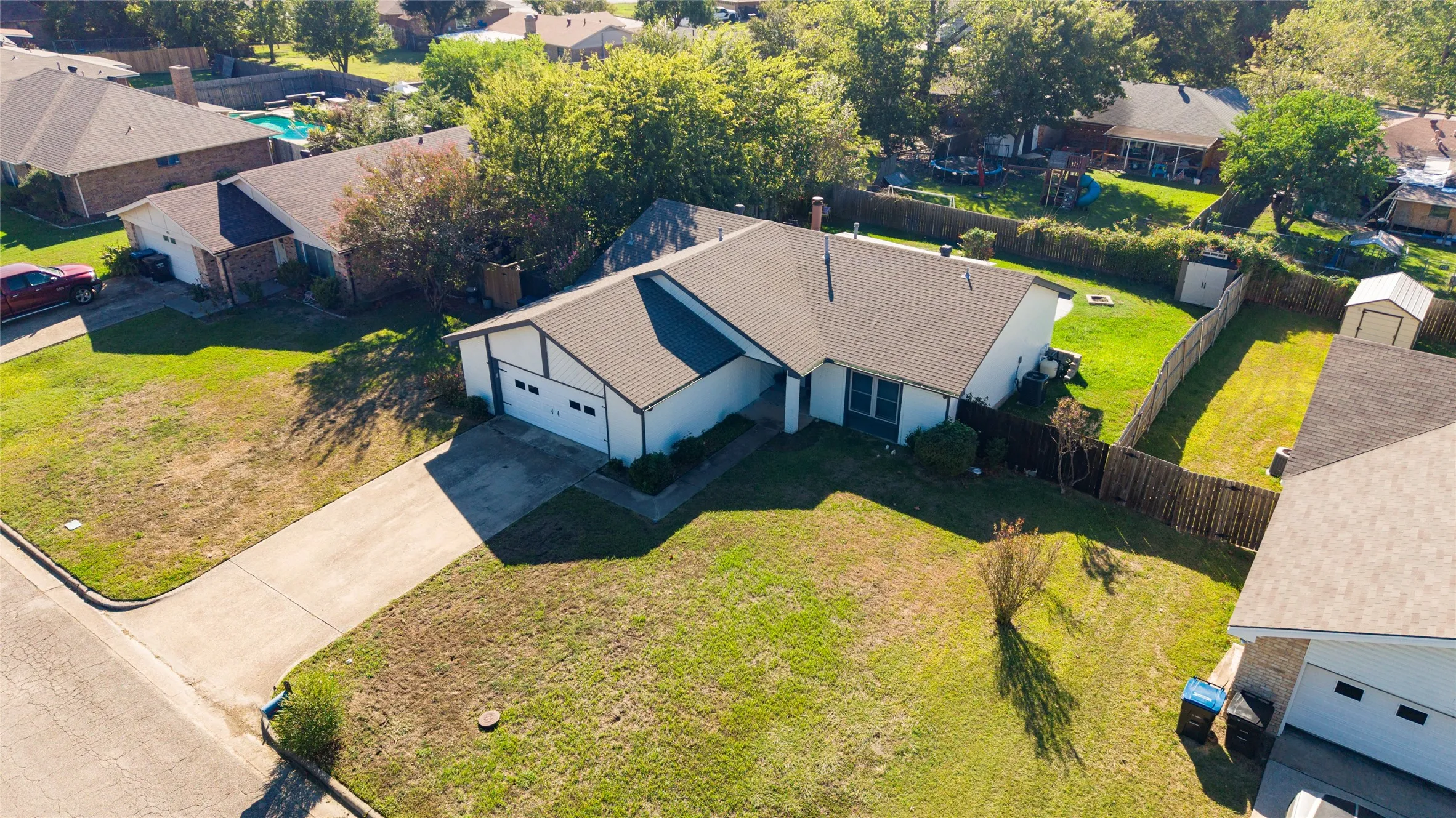 Single-story residence featuring a two-car garage, pitched roof, and a fenced backyard