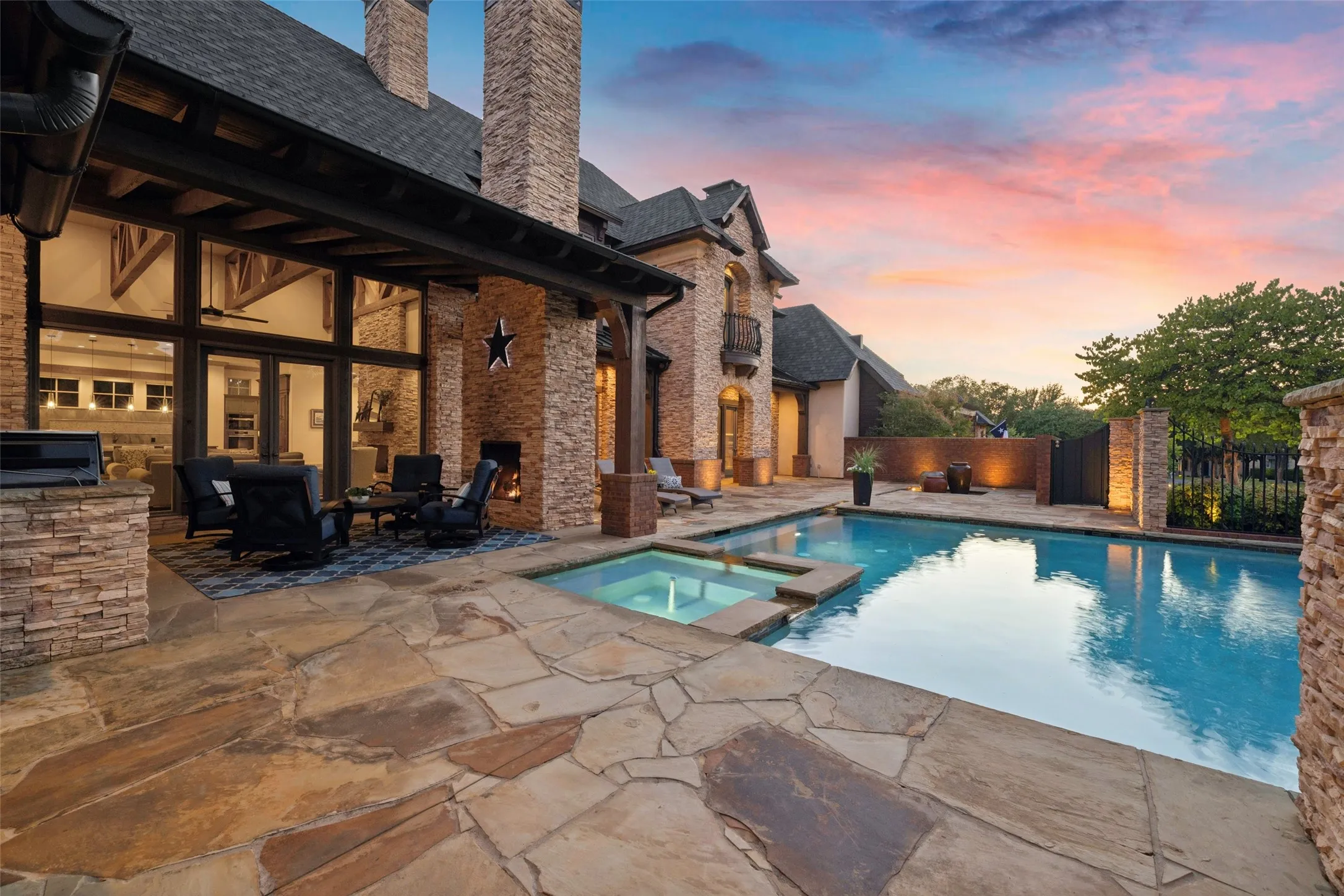 The deep covered cedar loggia offers an inviting open-air lounge with recessed lighting, exposed beams, and immediate access to the main living areas