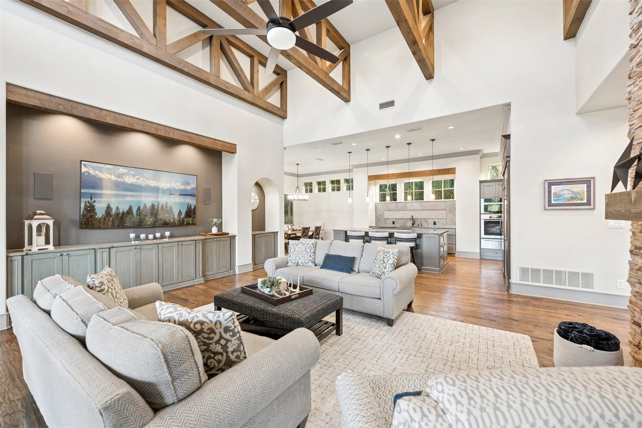 Rich hardwood floors anchor an expansive layout that flows effortlessly from the living room into the kitchen and dining areas.