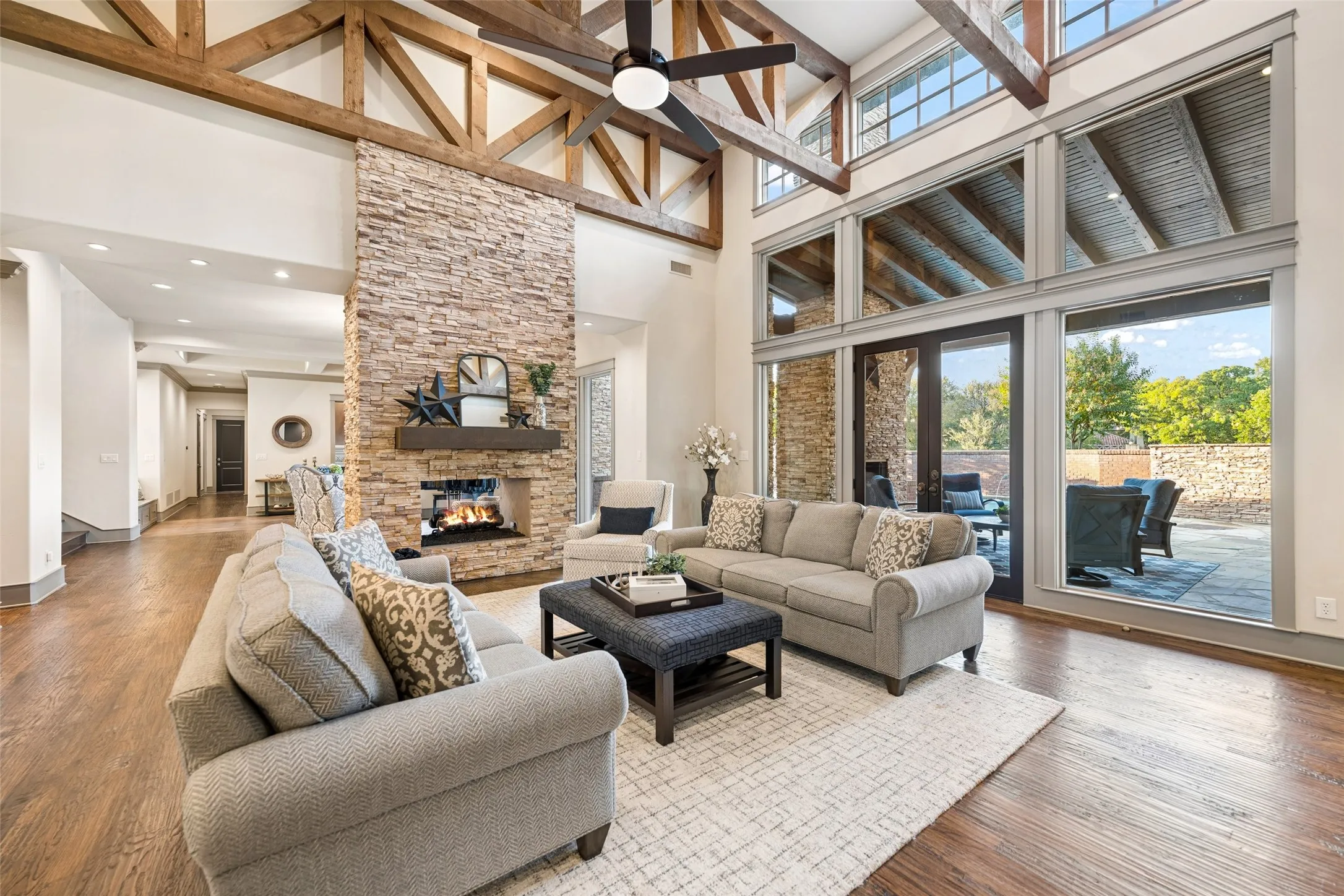 Soaring cathedral ceilings accented with rustic cedar trusses and exposed beams elevate the main living space.