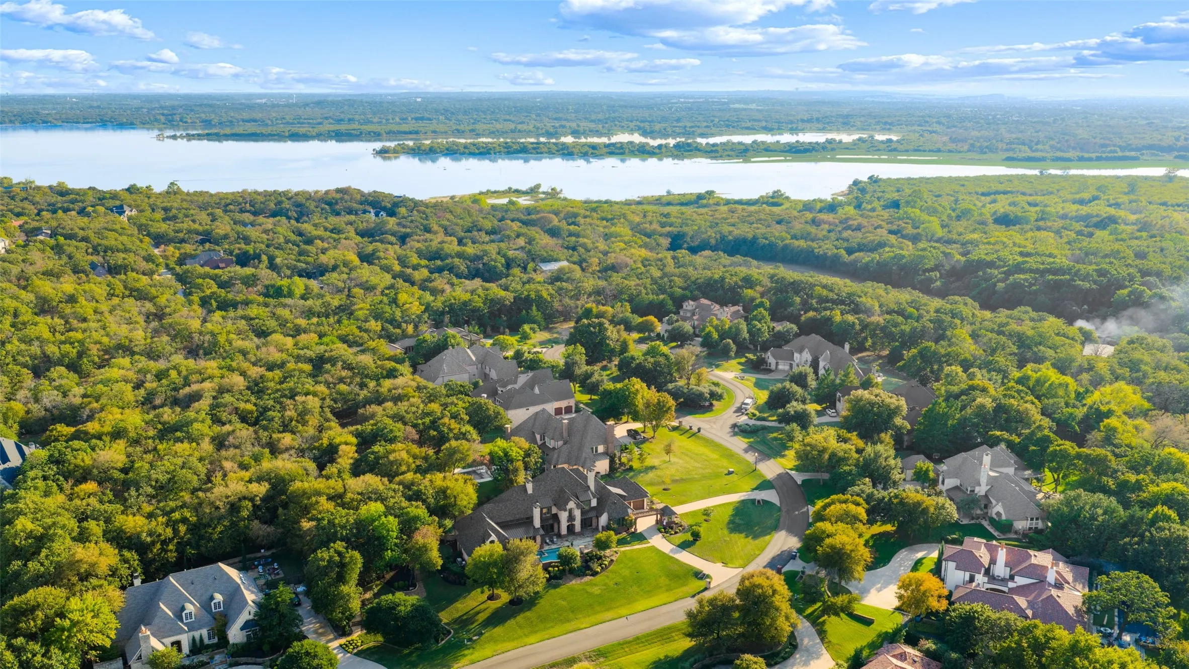 Expansive tree-lined terrain and protected nature reserves frame this elite Chimney Rock neighborhood against the backdrop of Grapevine Lake.