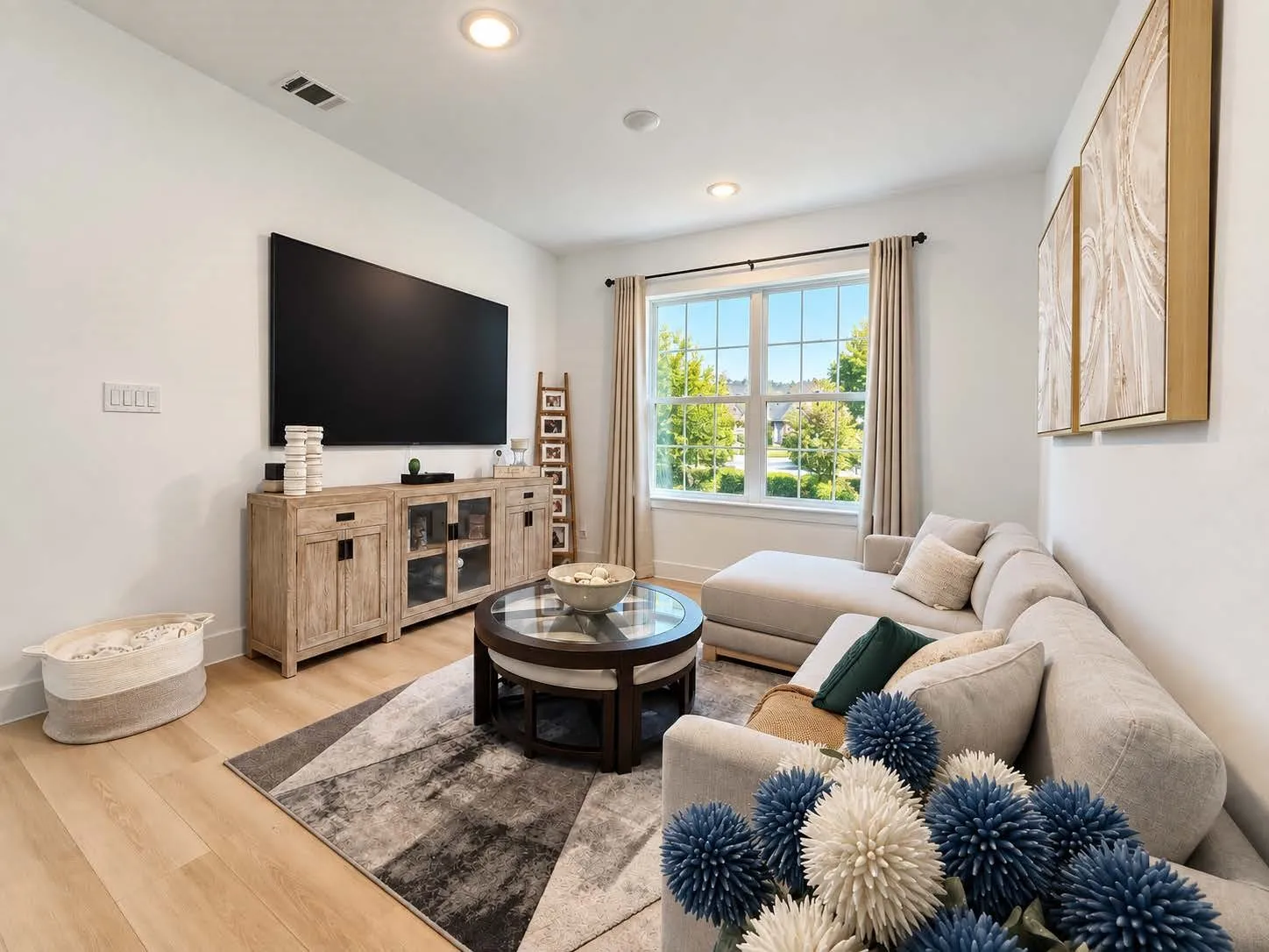 Recessed ceiling lighting, wood-finish flooring, a large picture window, and a light-toned sectional