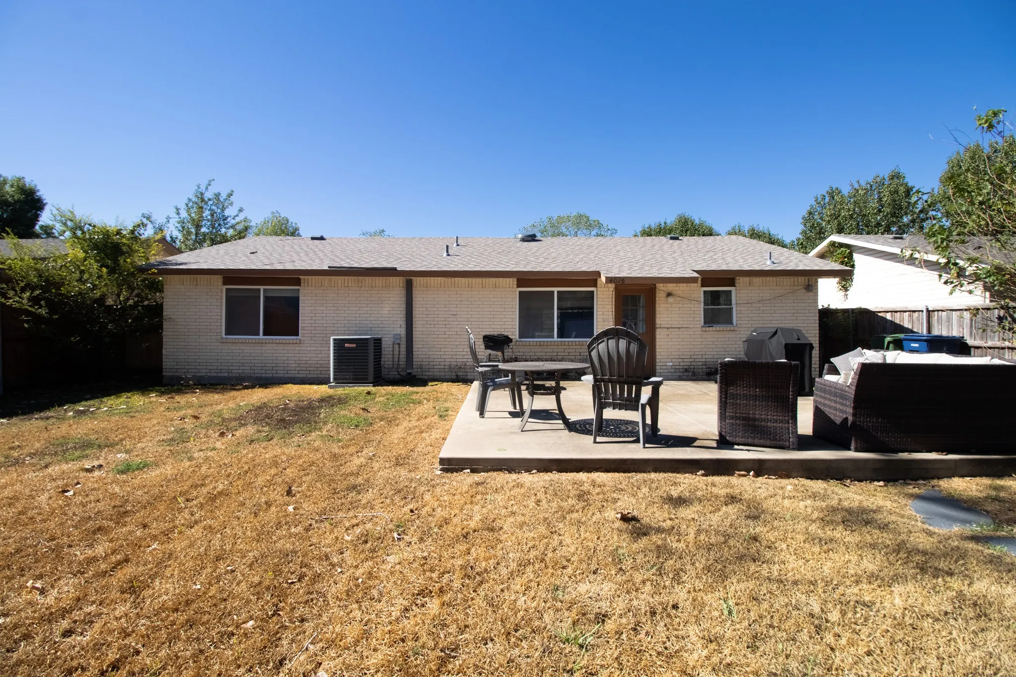 Spacious, fenced backyard with expanded open patio and shed.
