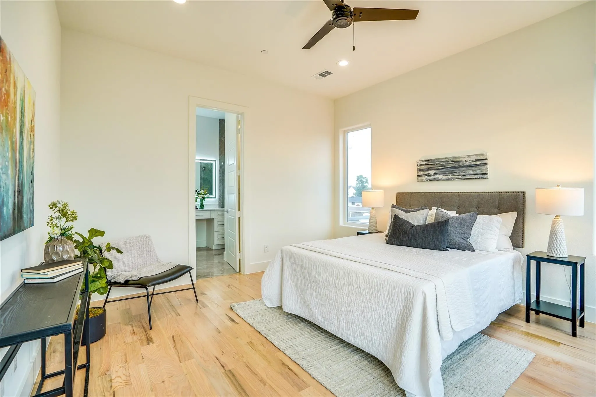 Spacious bedroom with light wood-finish flooring, a vaulted ceiling, and recessed lighting