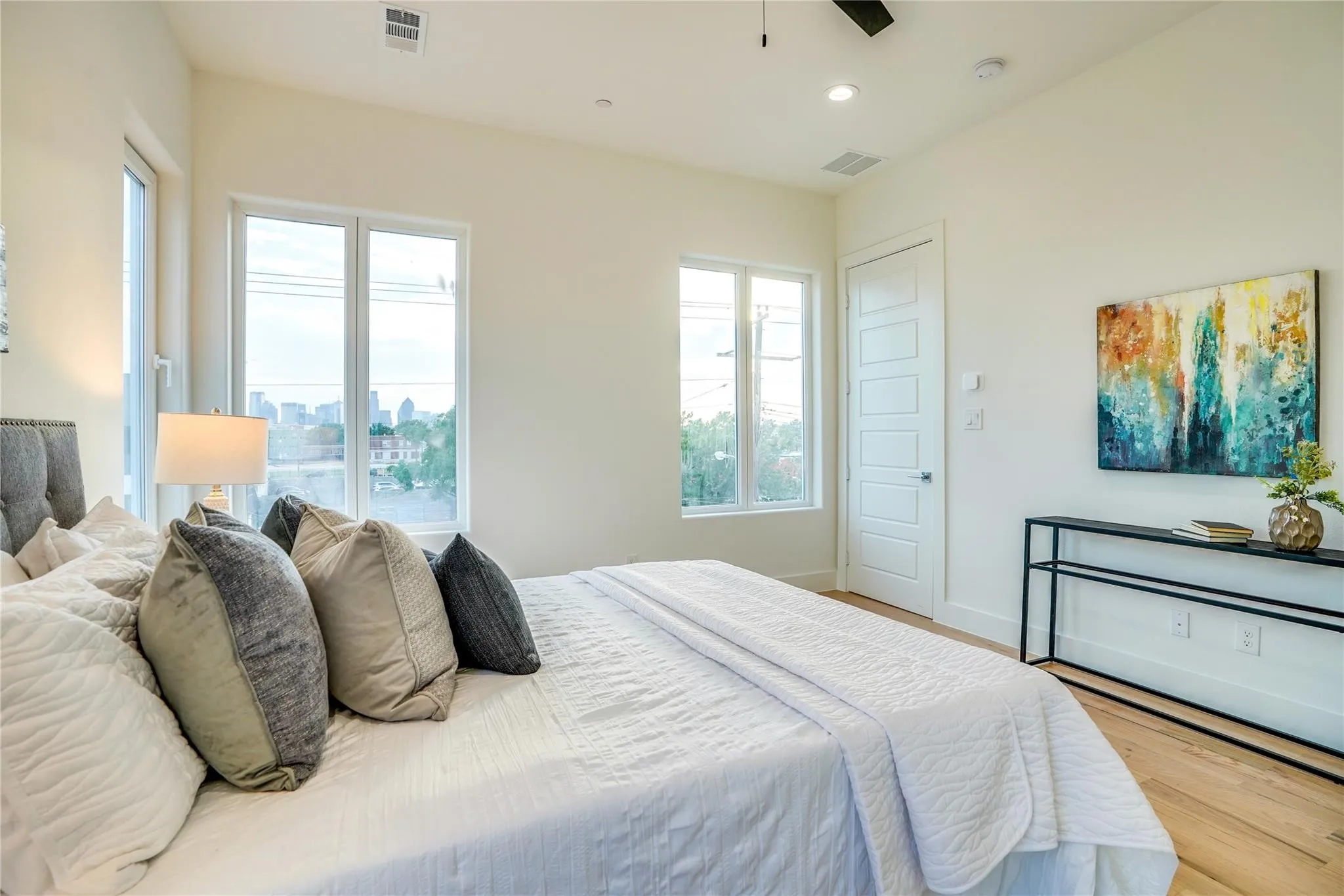 Bedroom featuring light wood-finish flooring, white walls, and a multi-pane window configuration