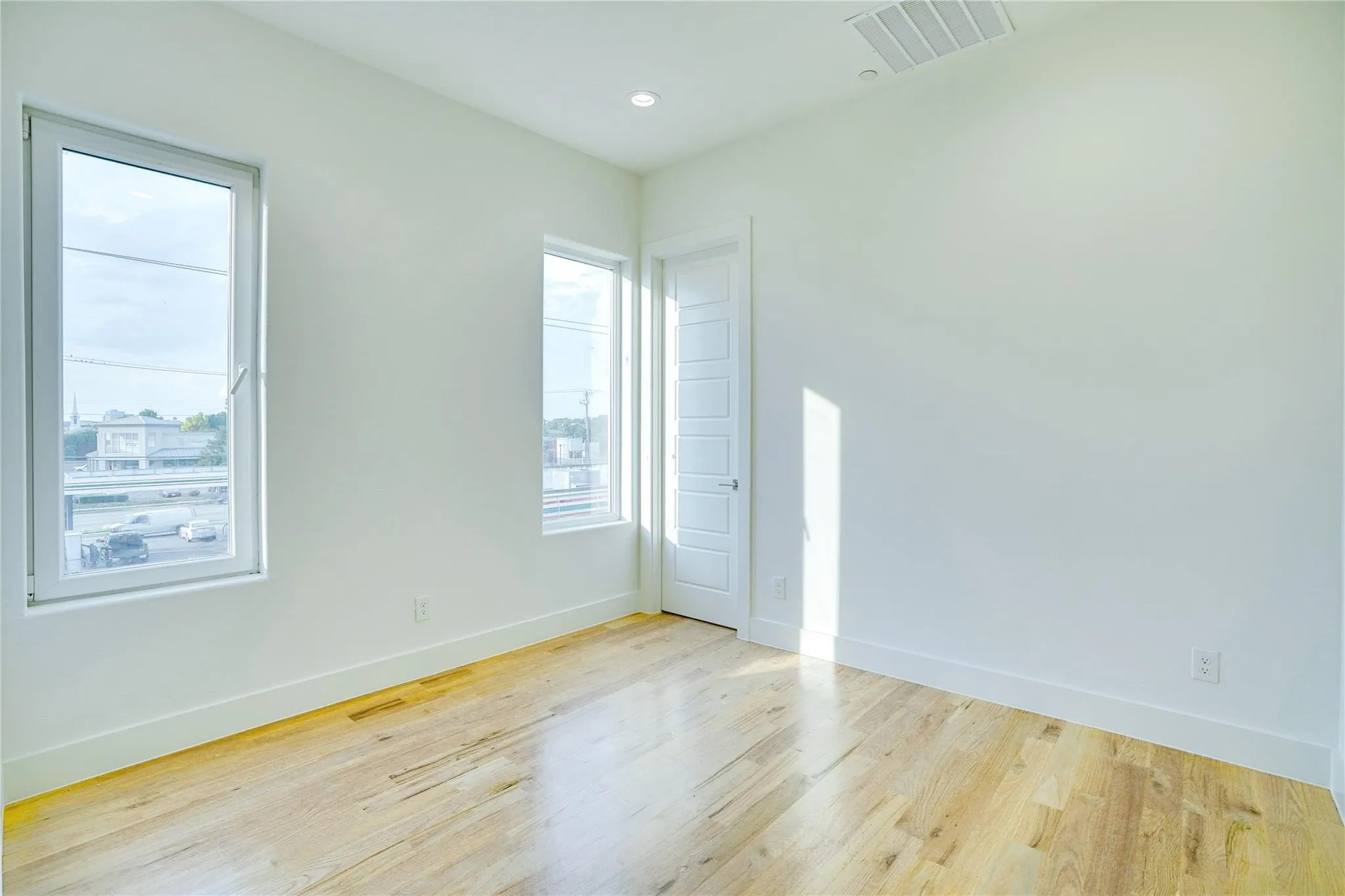 Room featuring light wood-finish flooring, white walls, and bright overhead lighting