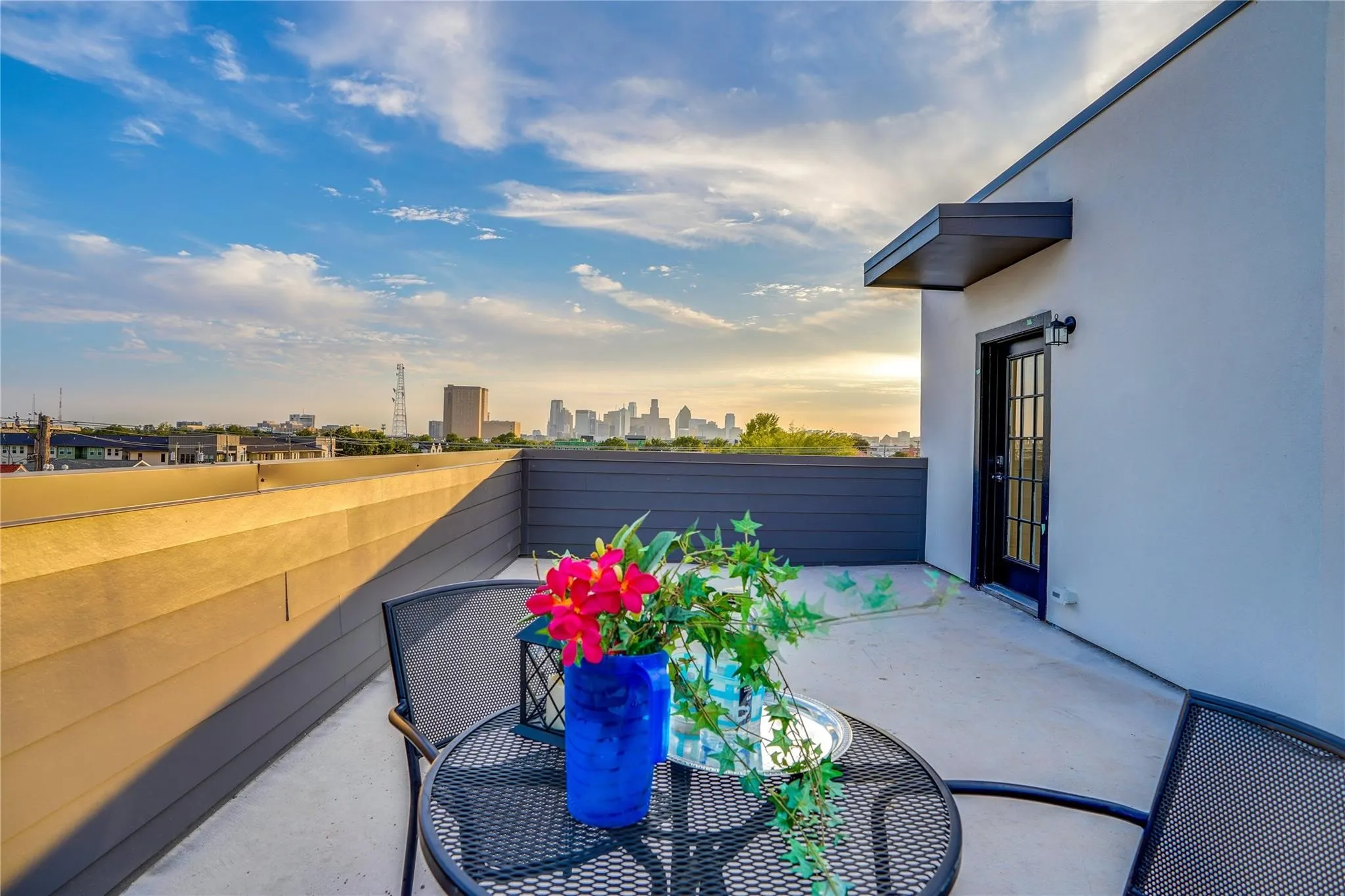 Rooftop terrace featuring a concrete surface, a black framed glass-paned door, and a protective awning