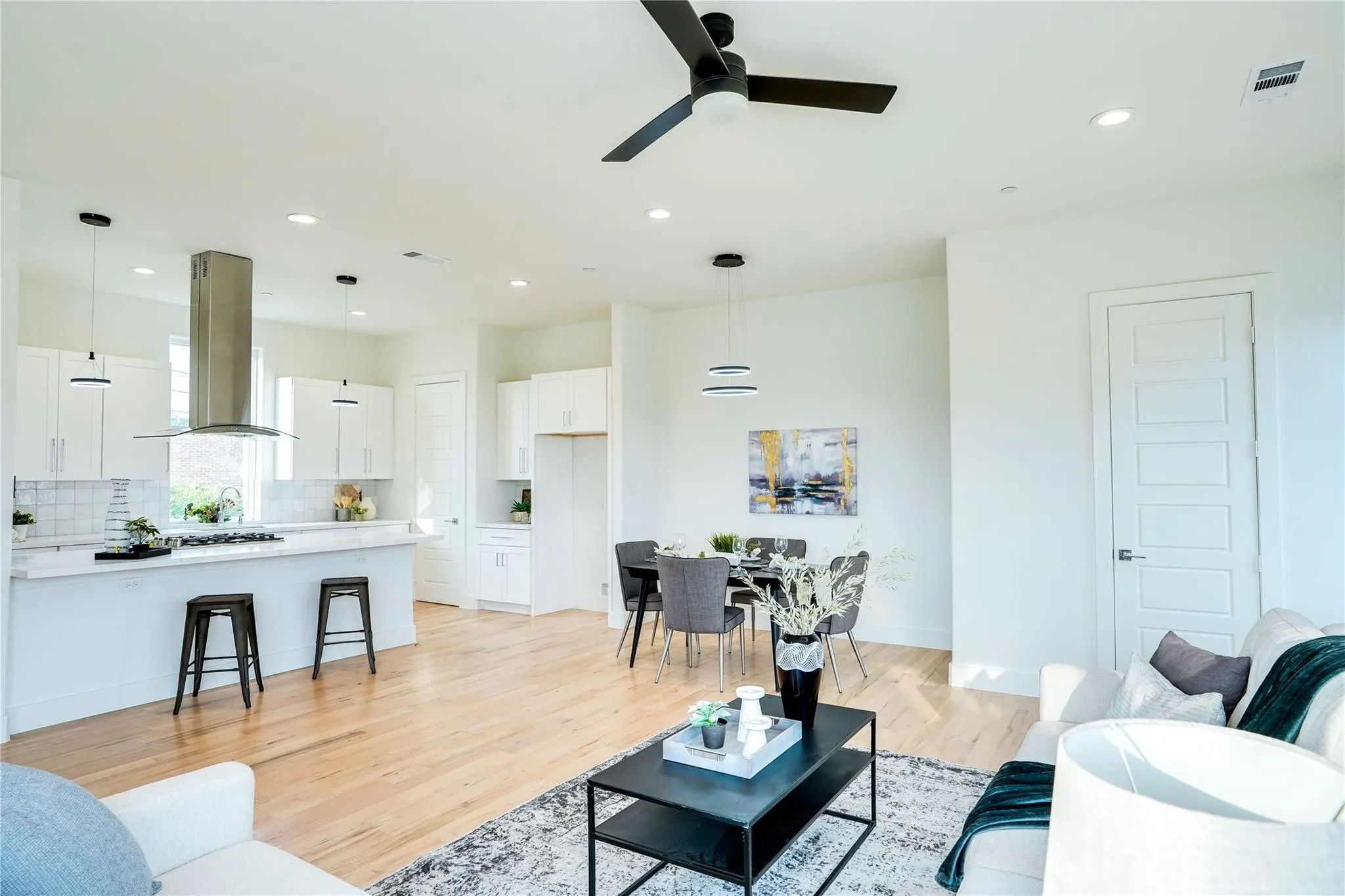 Open-concept living space featuring wood-finish flooring, recessed lighting, and a contemporary ceiling fan