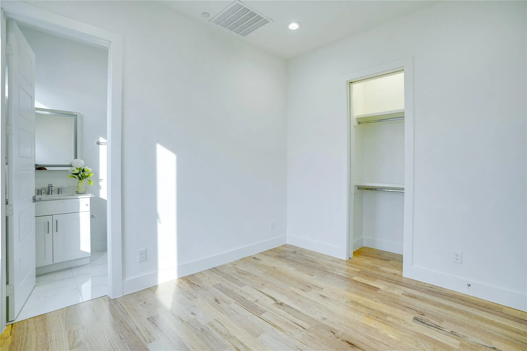 Room featuring light wood-finish flooring, white walls, and a recessed ceiling light