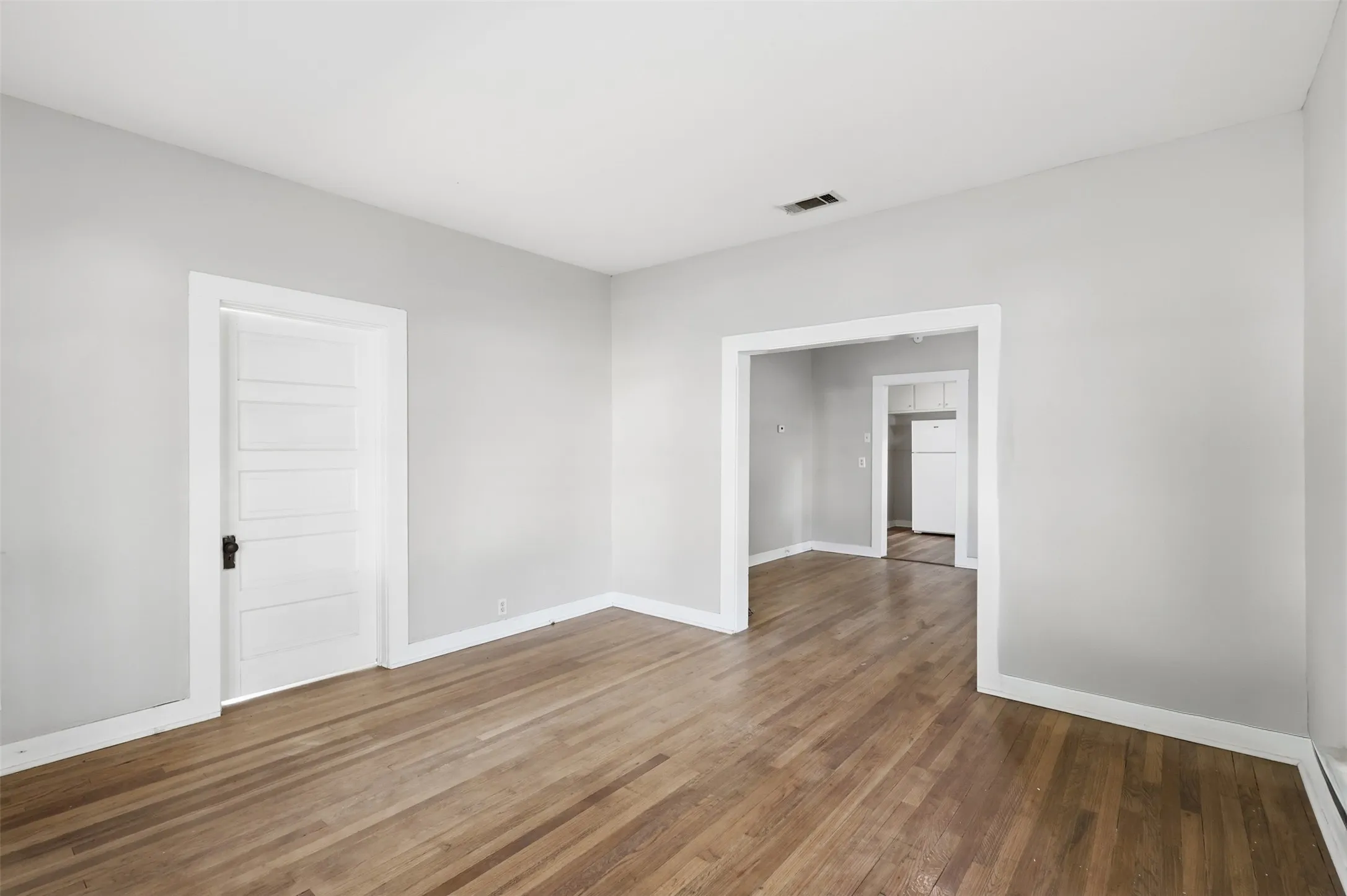 Hardwood flooring throughout, white baseboards, and light gray wall paint