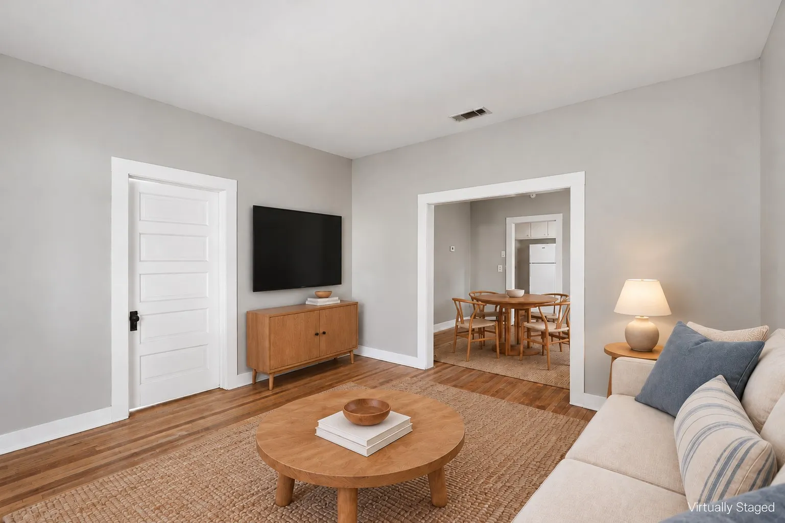 Hardwood-style flooring throughout, light gray wall finishes, and white trim