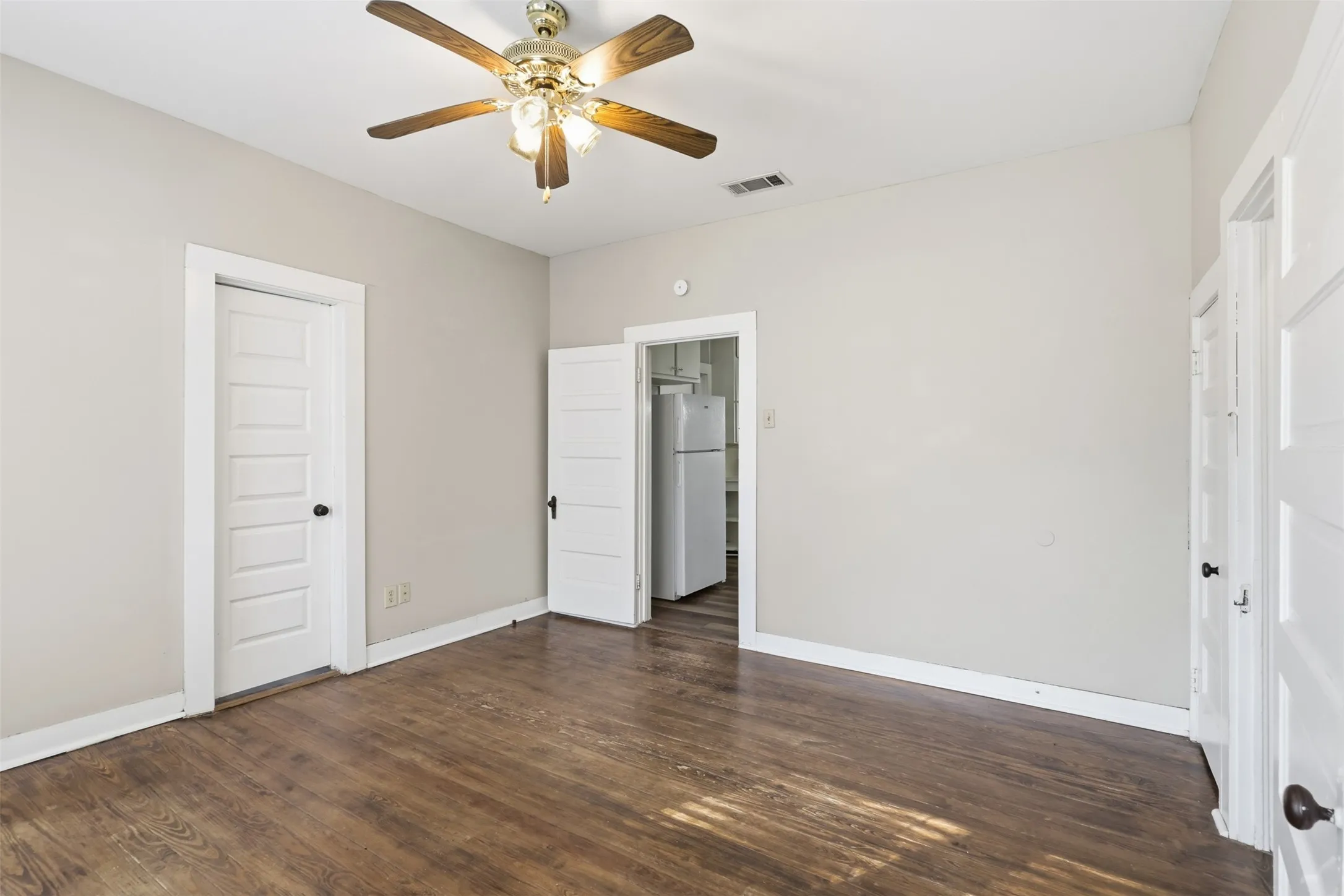 Hardwood-style flooring throughout, neutral wall tones, and overhead ceiling fan