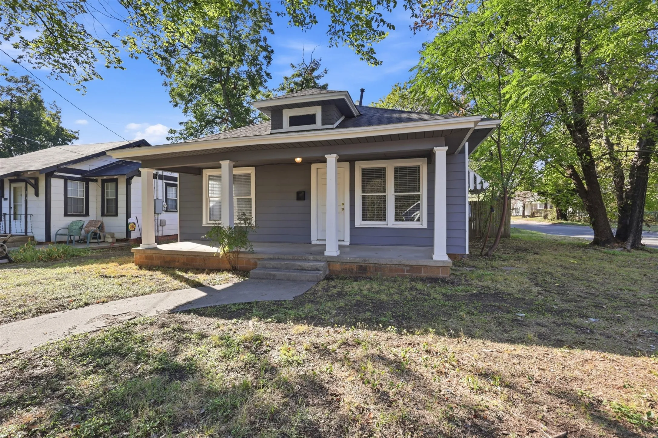 Front exterior with a covered porch, column supports, and a dormer