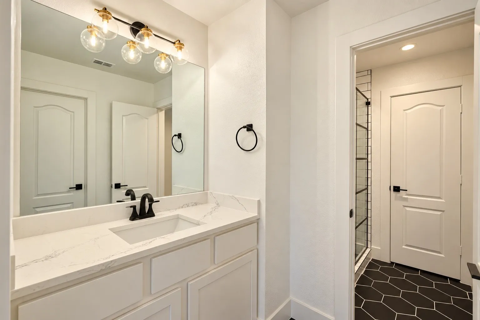 White vanity with an integrated rectangular sink, quartz countertop, and matte black faucet
