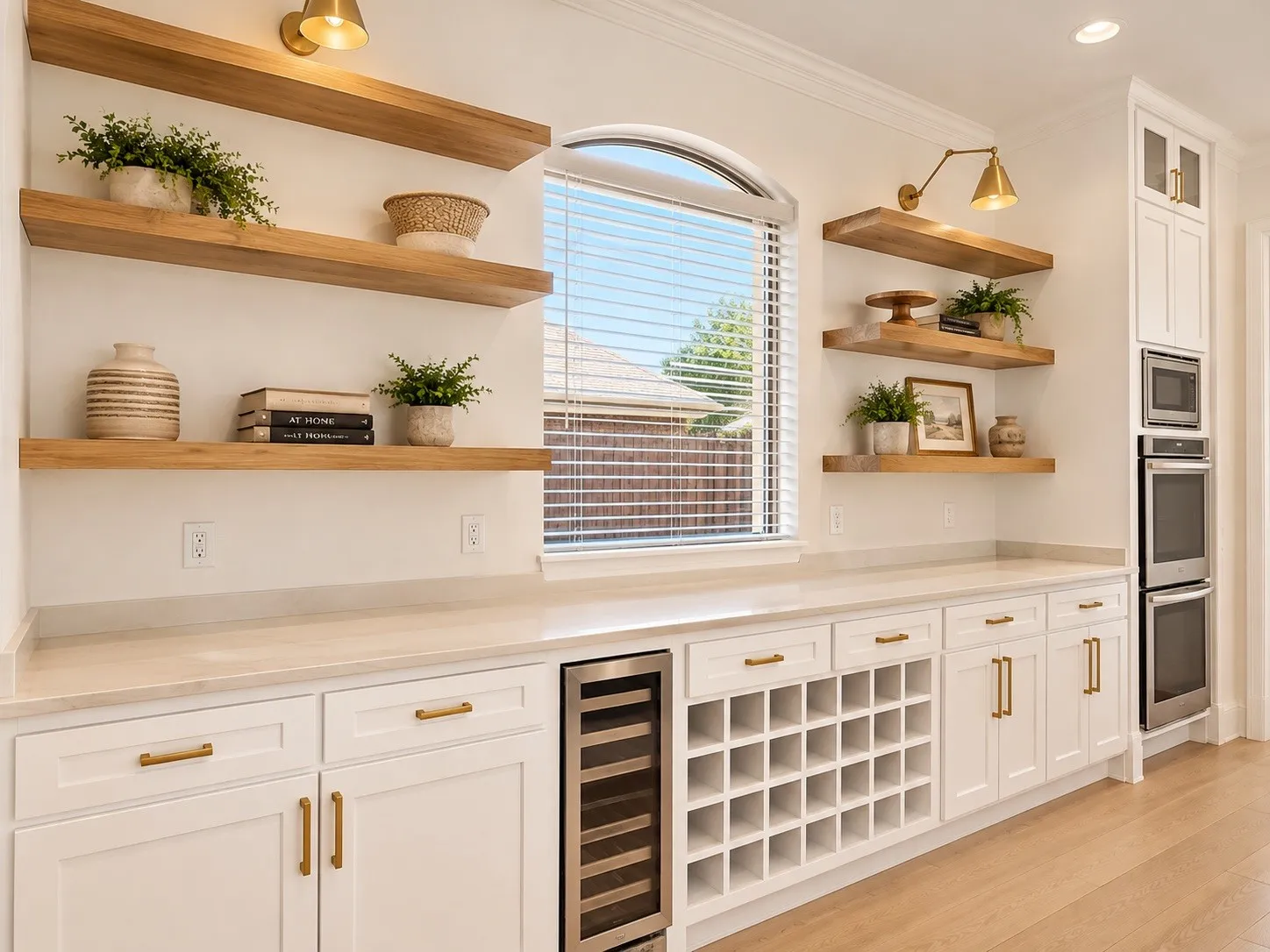 Built-in cabinetry with white shaker-style doors, light-toned countertops, and brass hardware