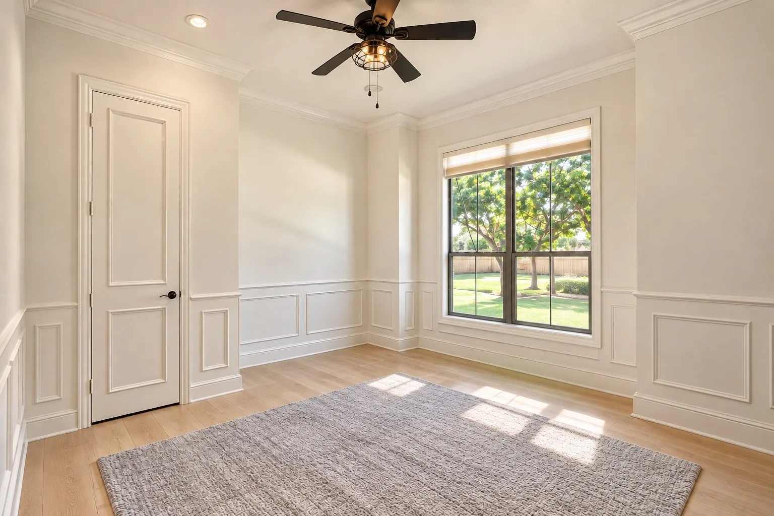 Wood-finish flooring, wainscoting, crown molding, recessed lighting, and a ceiling fan with integrated lighting