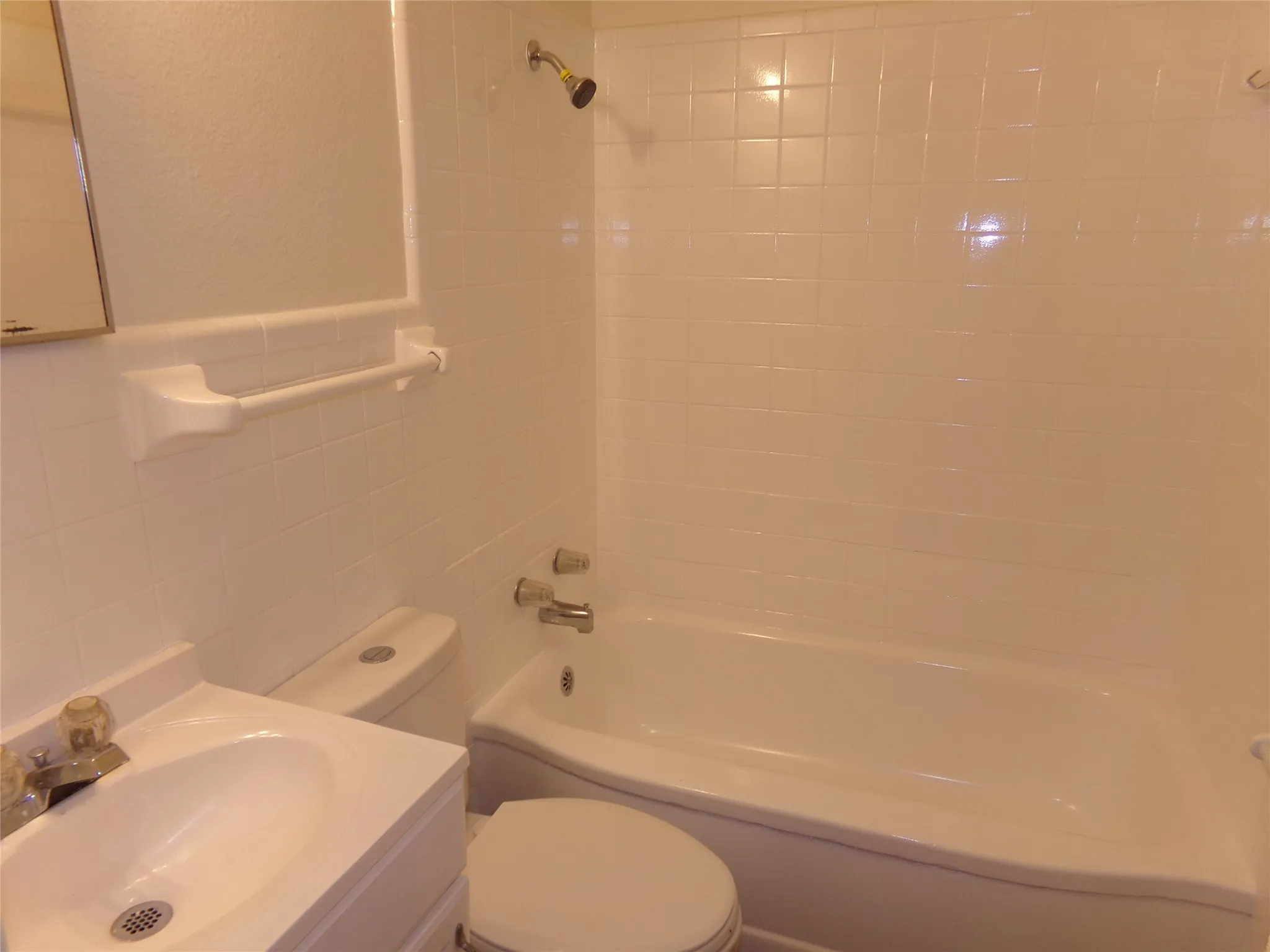 White tile shower surround, integrated bathtub, and vanity with basin sink