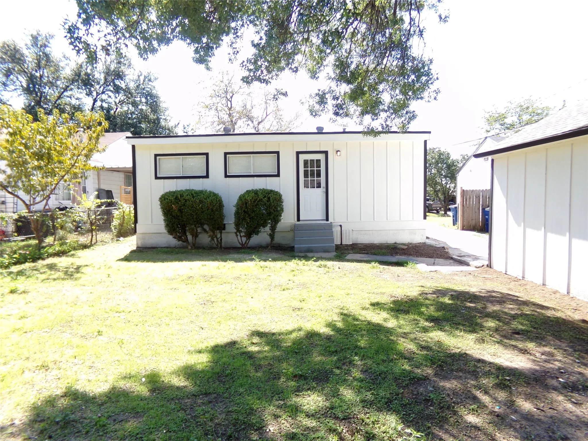 White vertical siding exterior with black trim windows