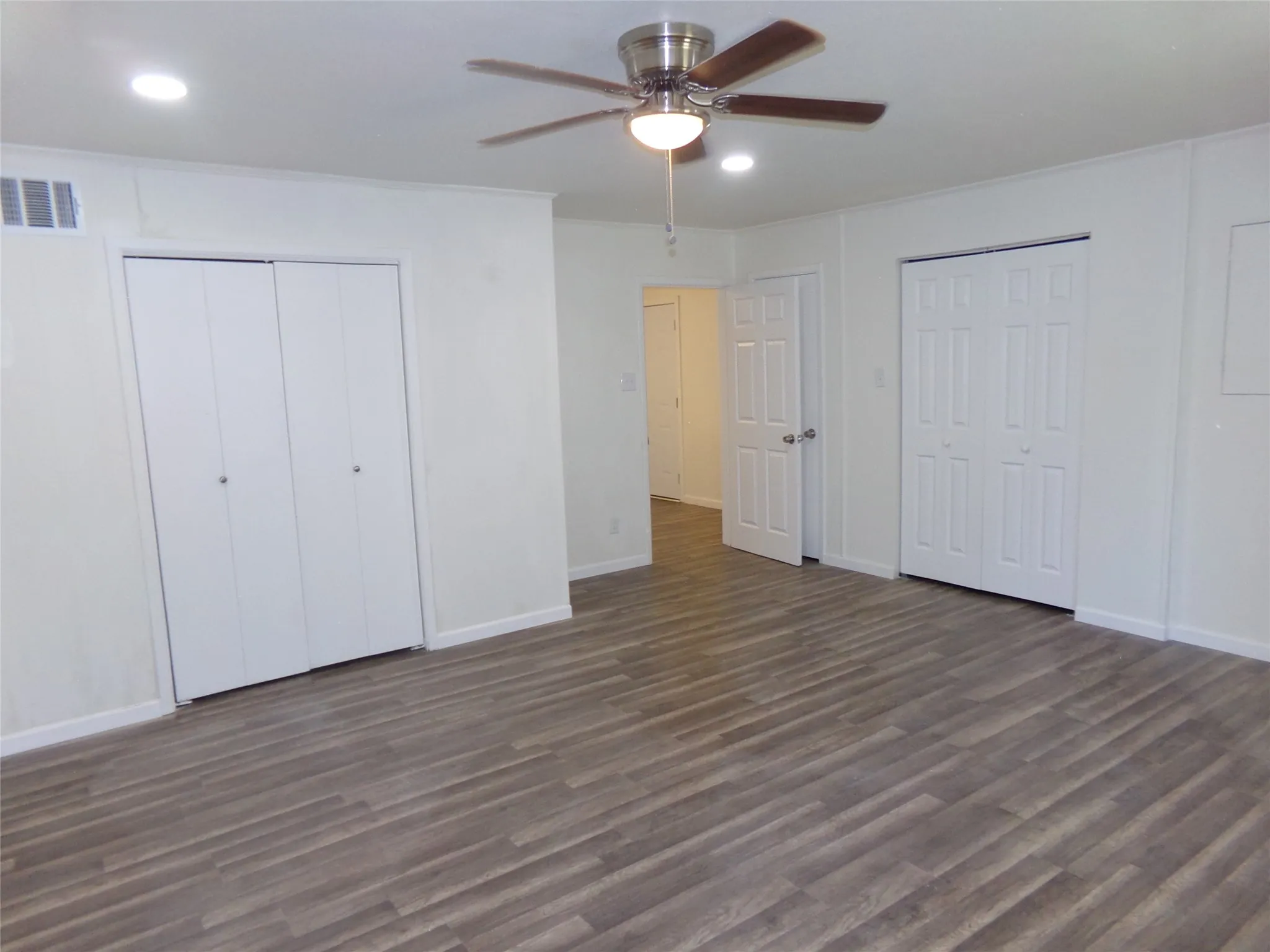 Wood-finish flooring, recessed lighting, and a ceiling fan with light fixture
