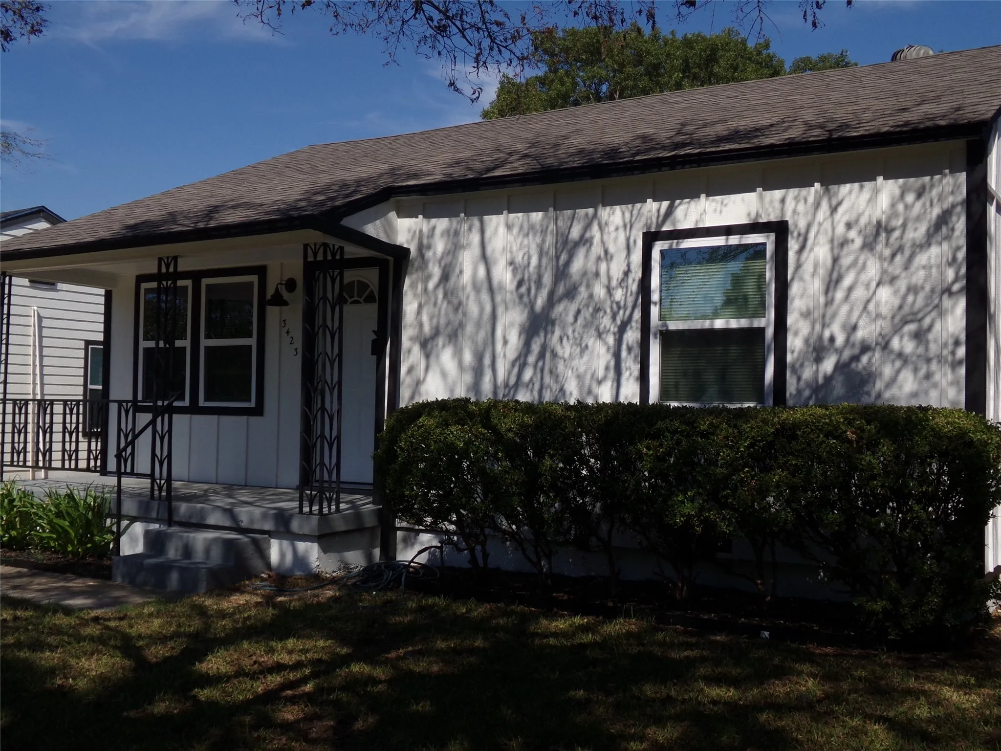 White vertical siding exterior with contrasting dark trim