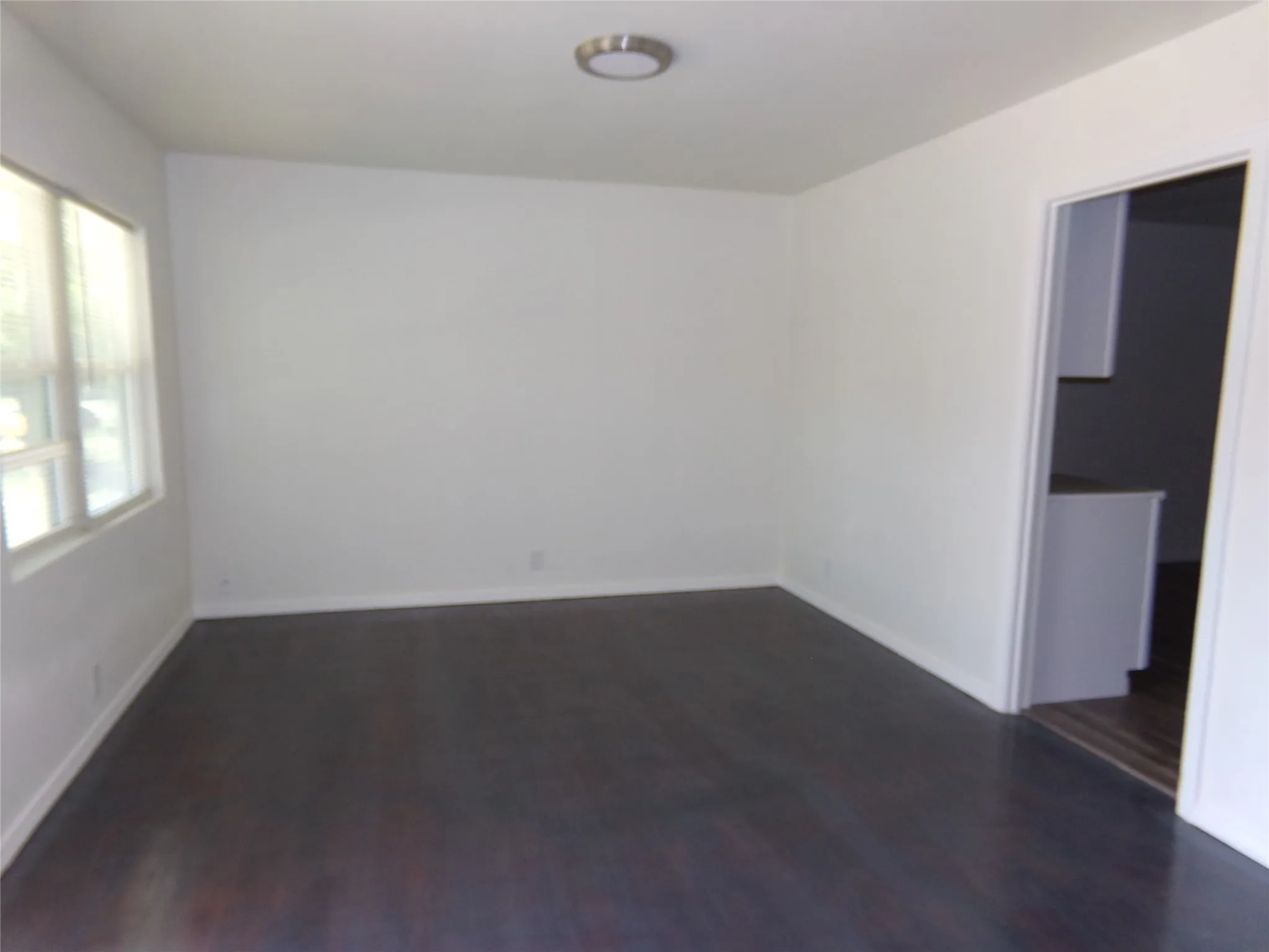 Dark wood-finish flooring with white baseboards