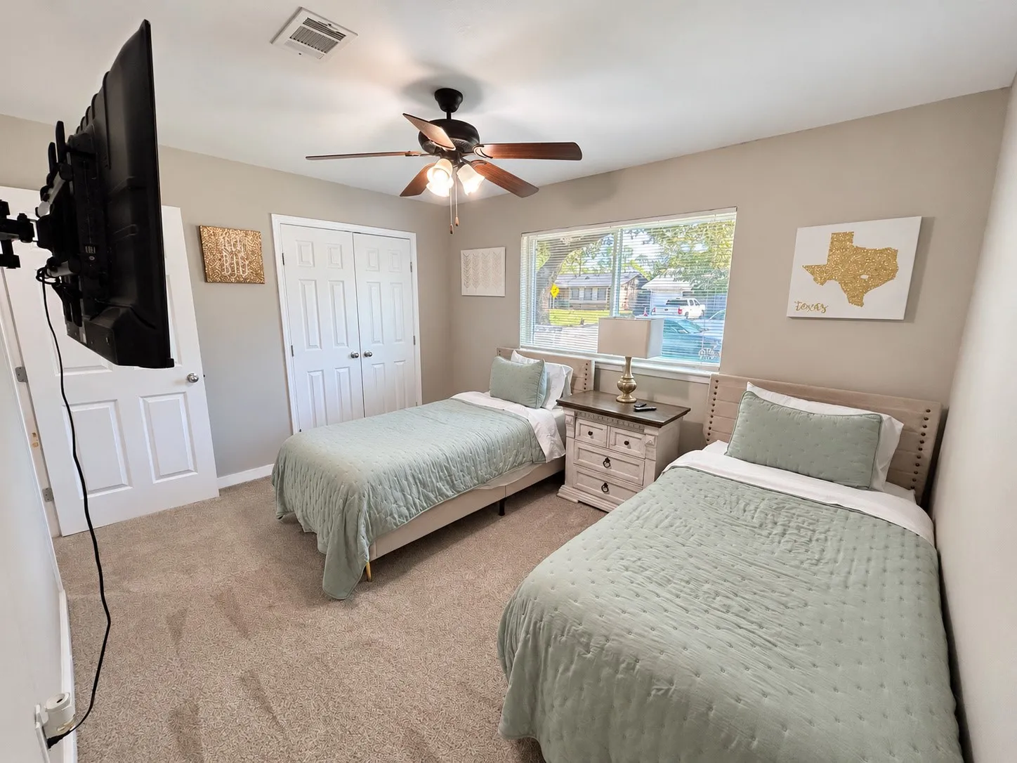 Carpeted flooring, ceiling fan, white paneled doors, and a window providing natural illumination