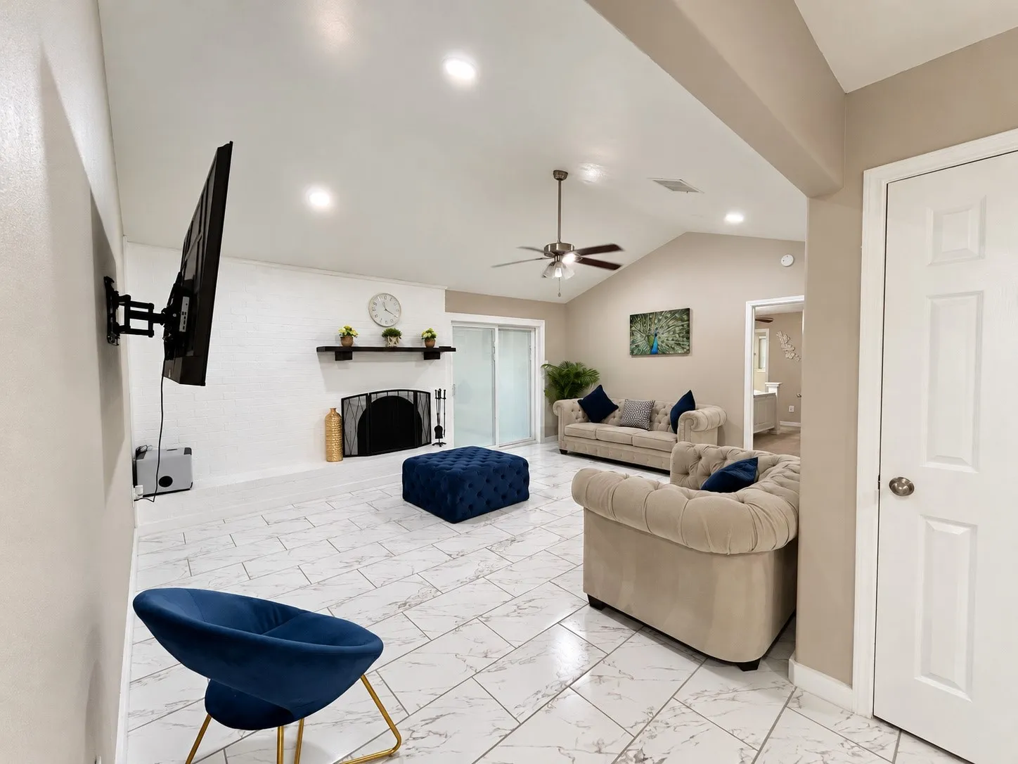 Vaulted ceiling with recessed lighting, ceiling fan, and white-painted brick fireplace