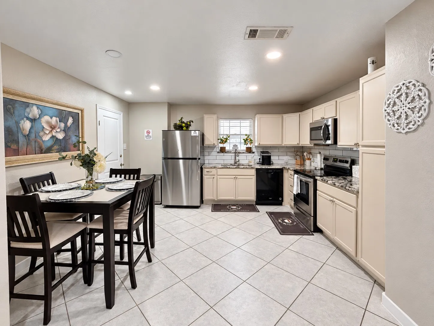 White tile flooring, recessed lighting, beige cabinetry, stainless steel refrigerator, and built-in microwave
