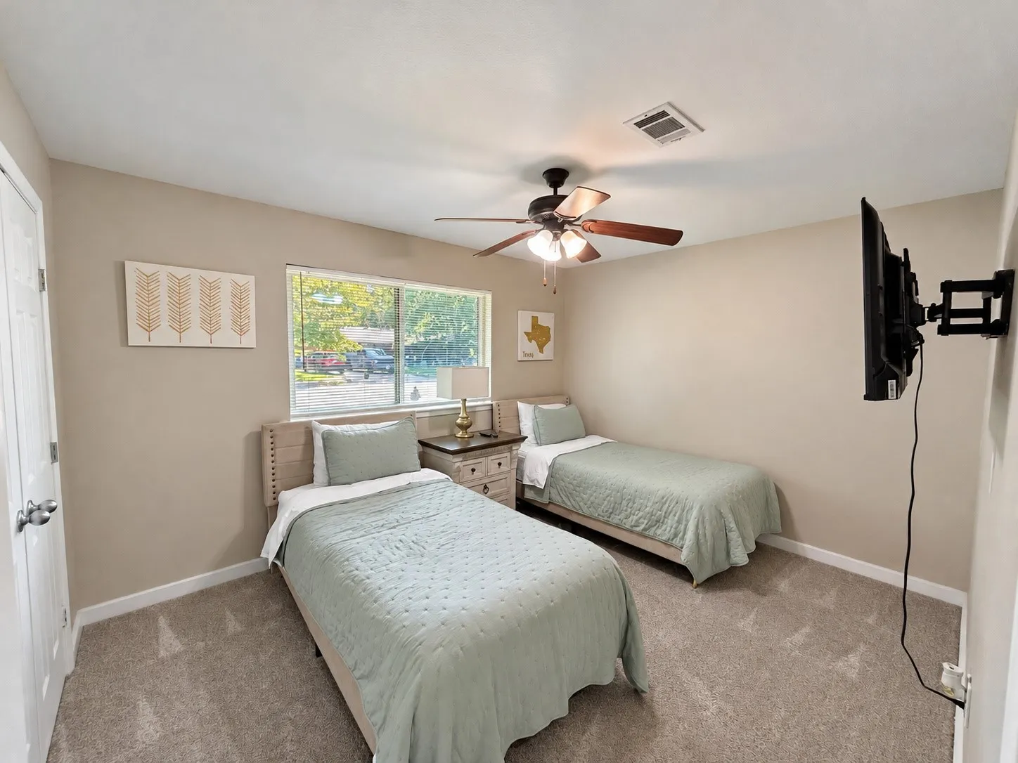 Carpeted flooring, neutral wall tones, window with natural light, ceiling fan with light fixture, and white trim