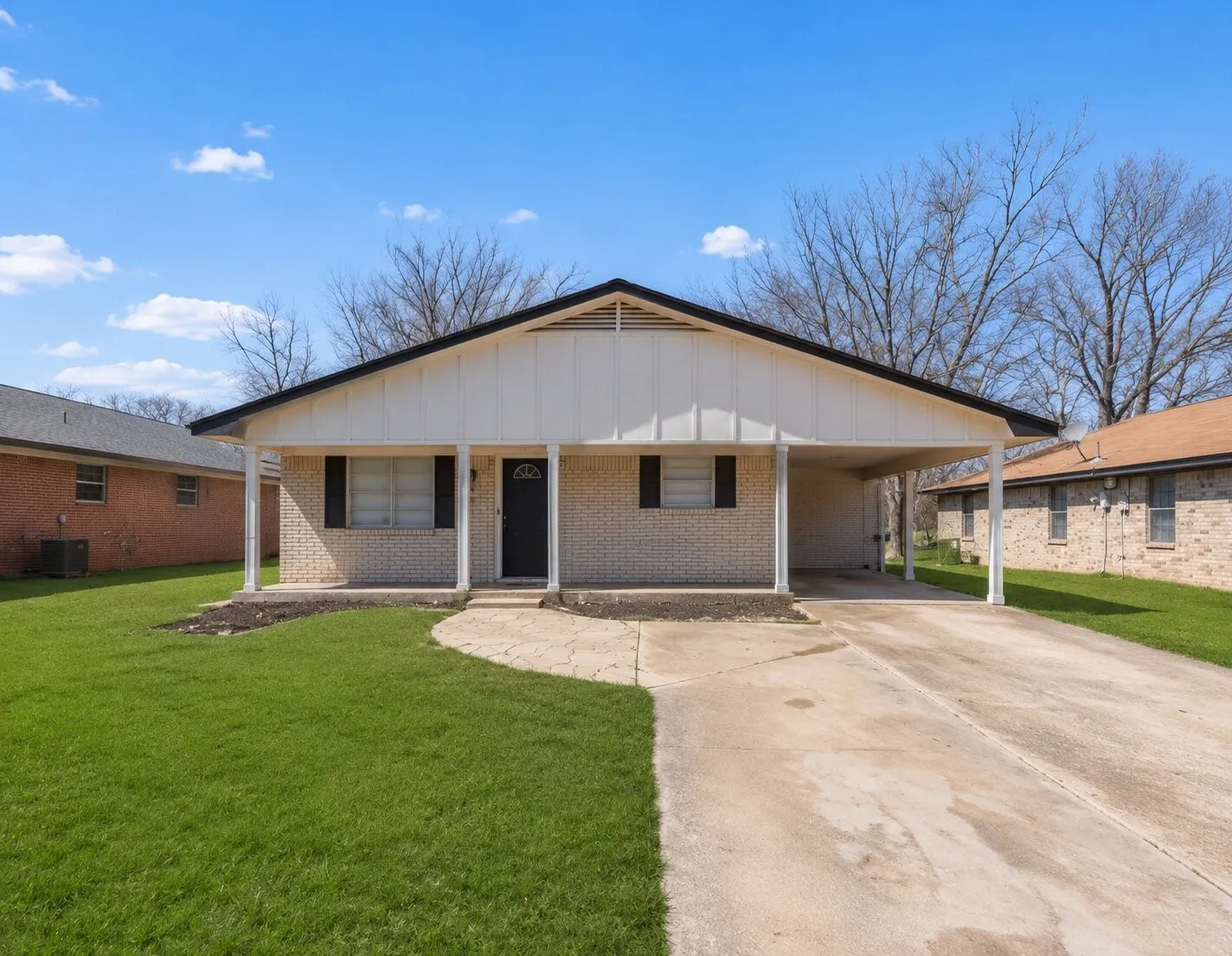 Brick exterior with white siding accents and a covered carport