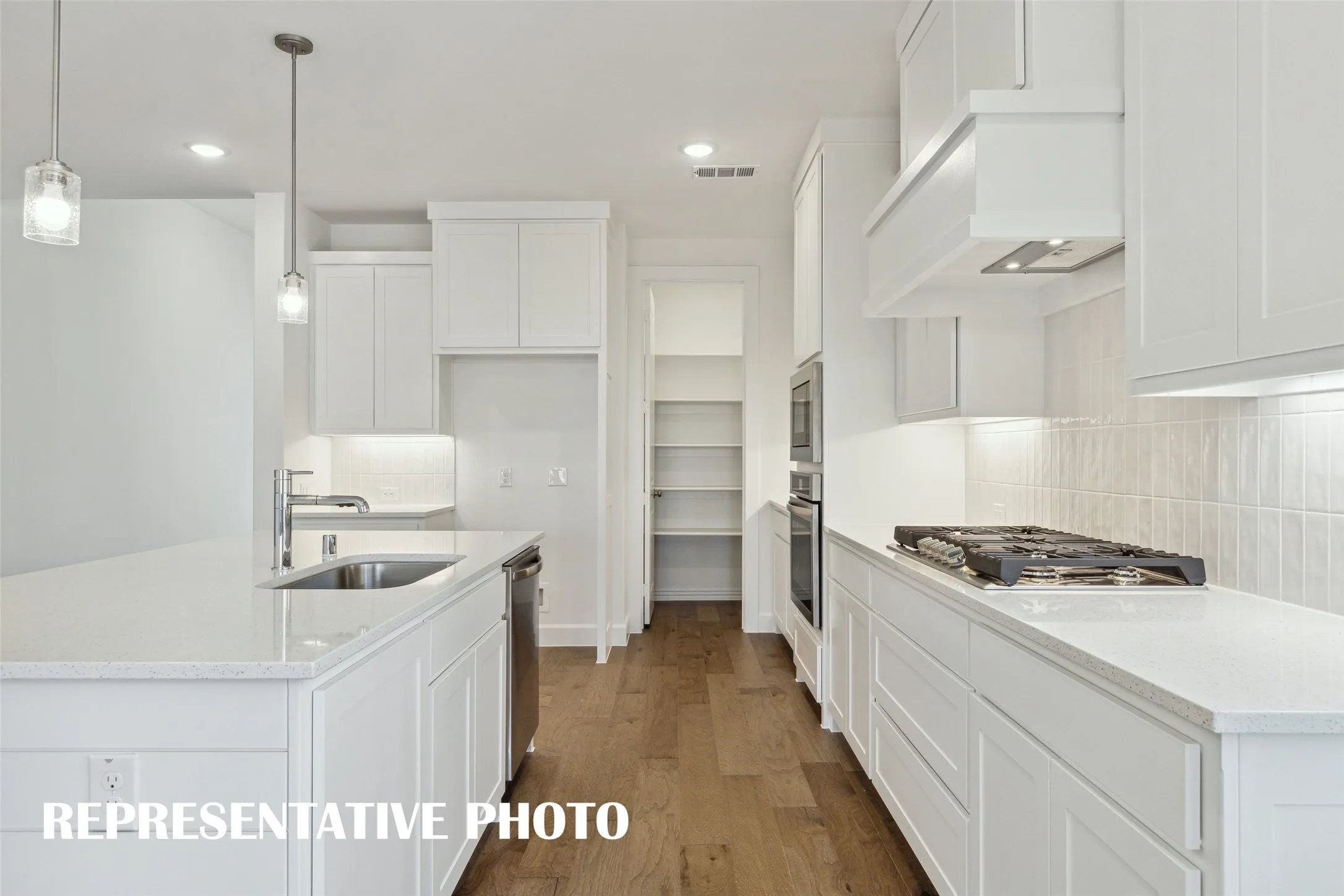 Beautiful cabinetry, stainless appliances and gorgeous flooring combine to make this dream kitchen a reality!  REPRESENTATIVE PHOTO