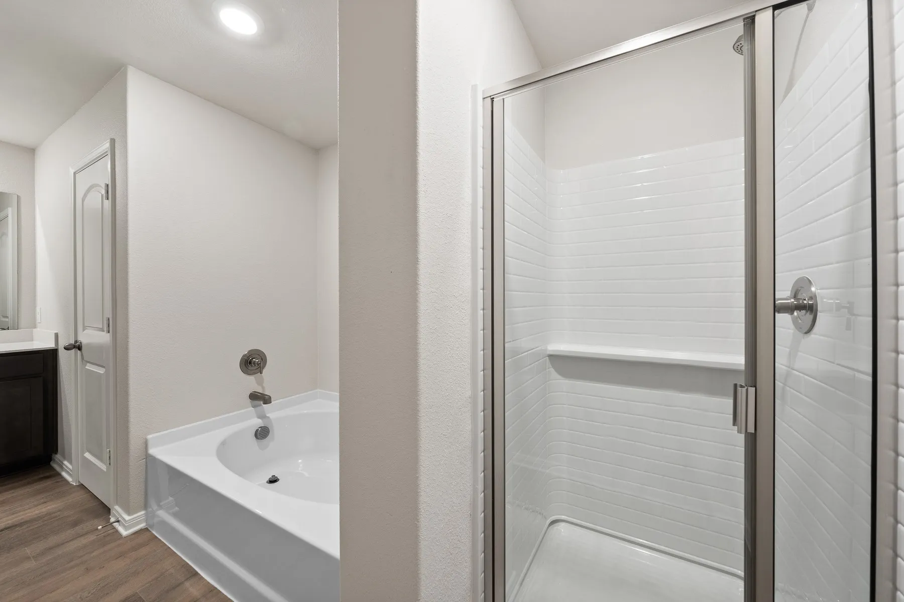 Bathroom featuring a bath, a shower stall, wood finished floors, and vanity