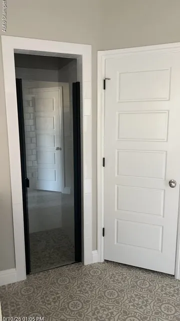 Glass-enclosed shower with black framing, white subway tile, and a patterned floor