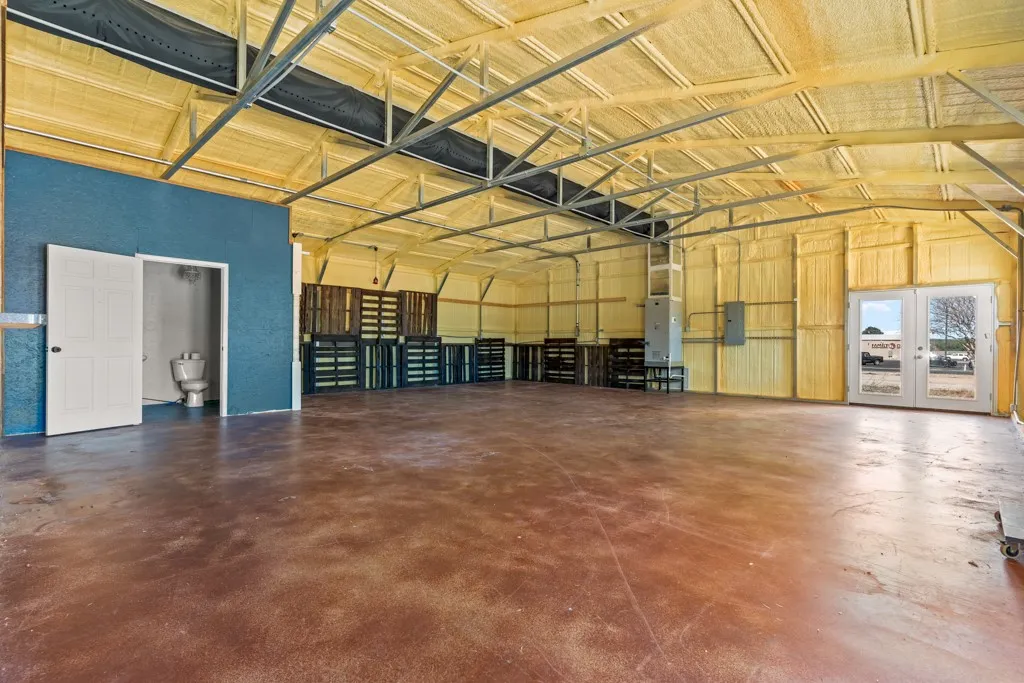 Spacious interior with exposed metal framing, spray foam insulation, and a concrete floor