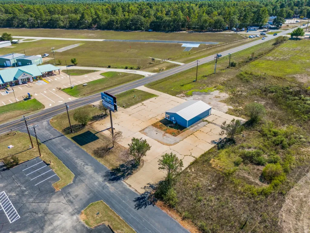 Blue commercial building with a metal roof and paved lot