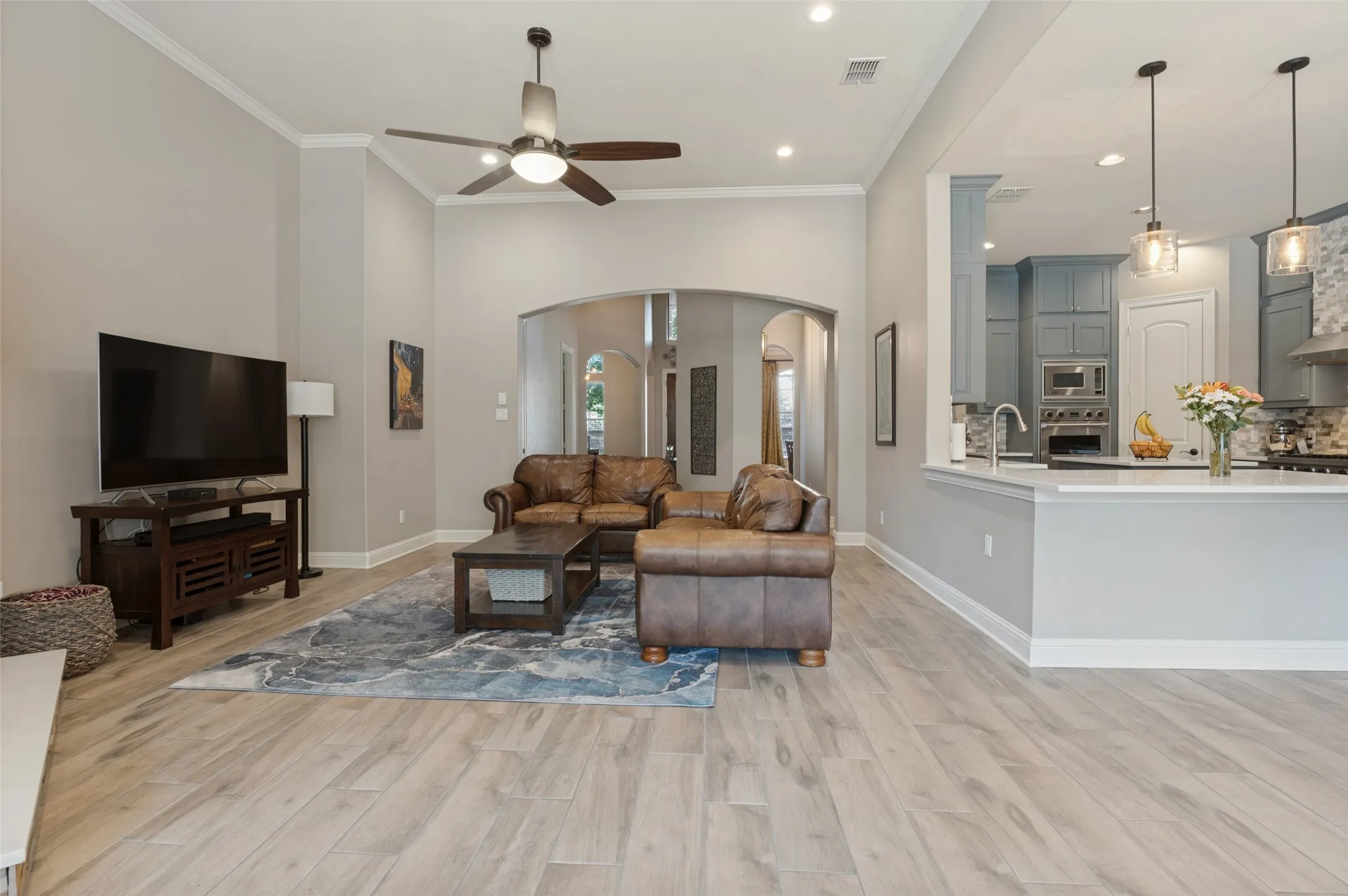 Spacious living area featuring wood-finish flooring, recessed lighting, and a ceiling fan