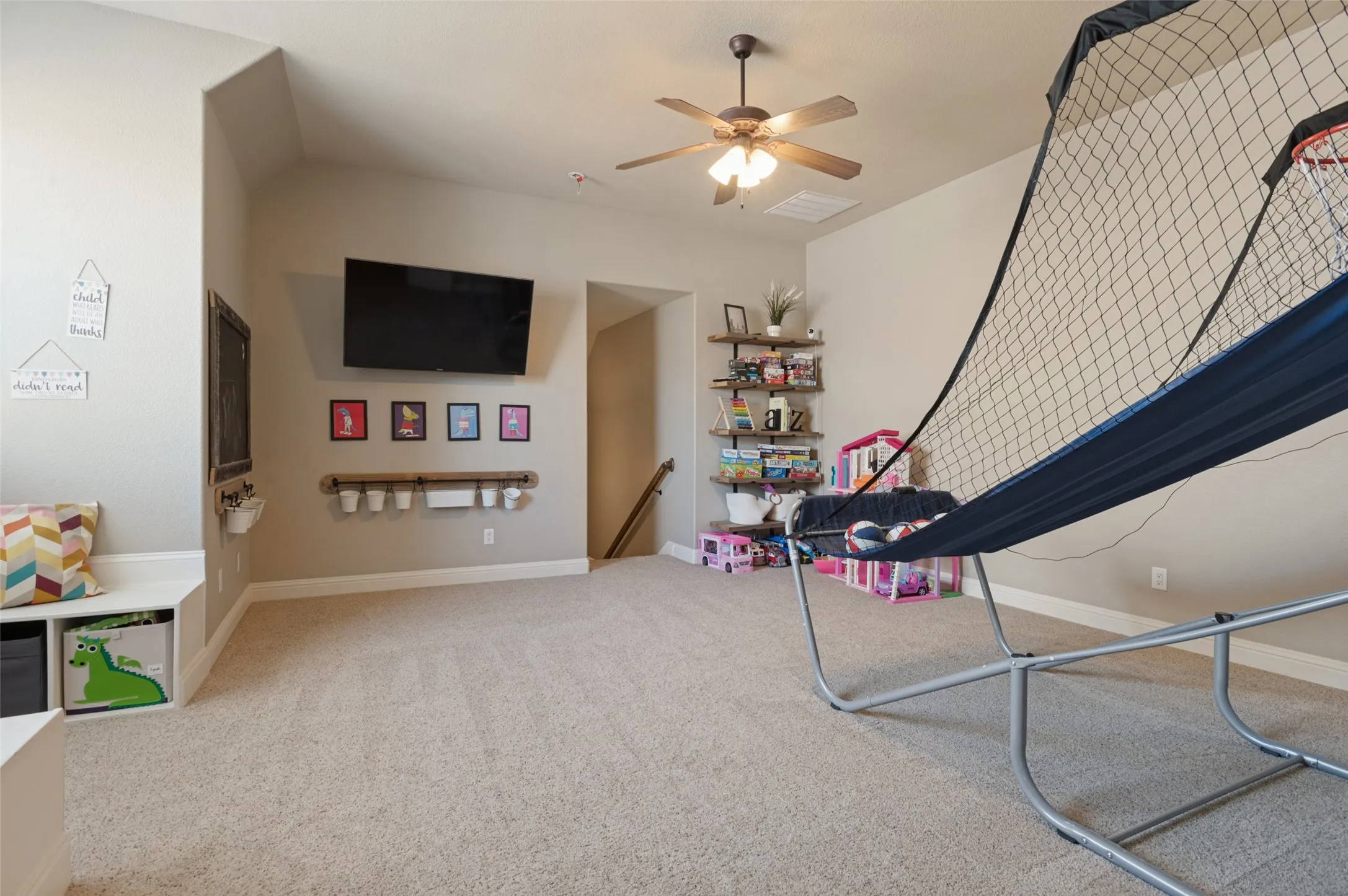 Carpeted room with a vaulted ceiling and a ceiling fan
