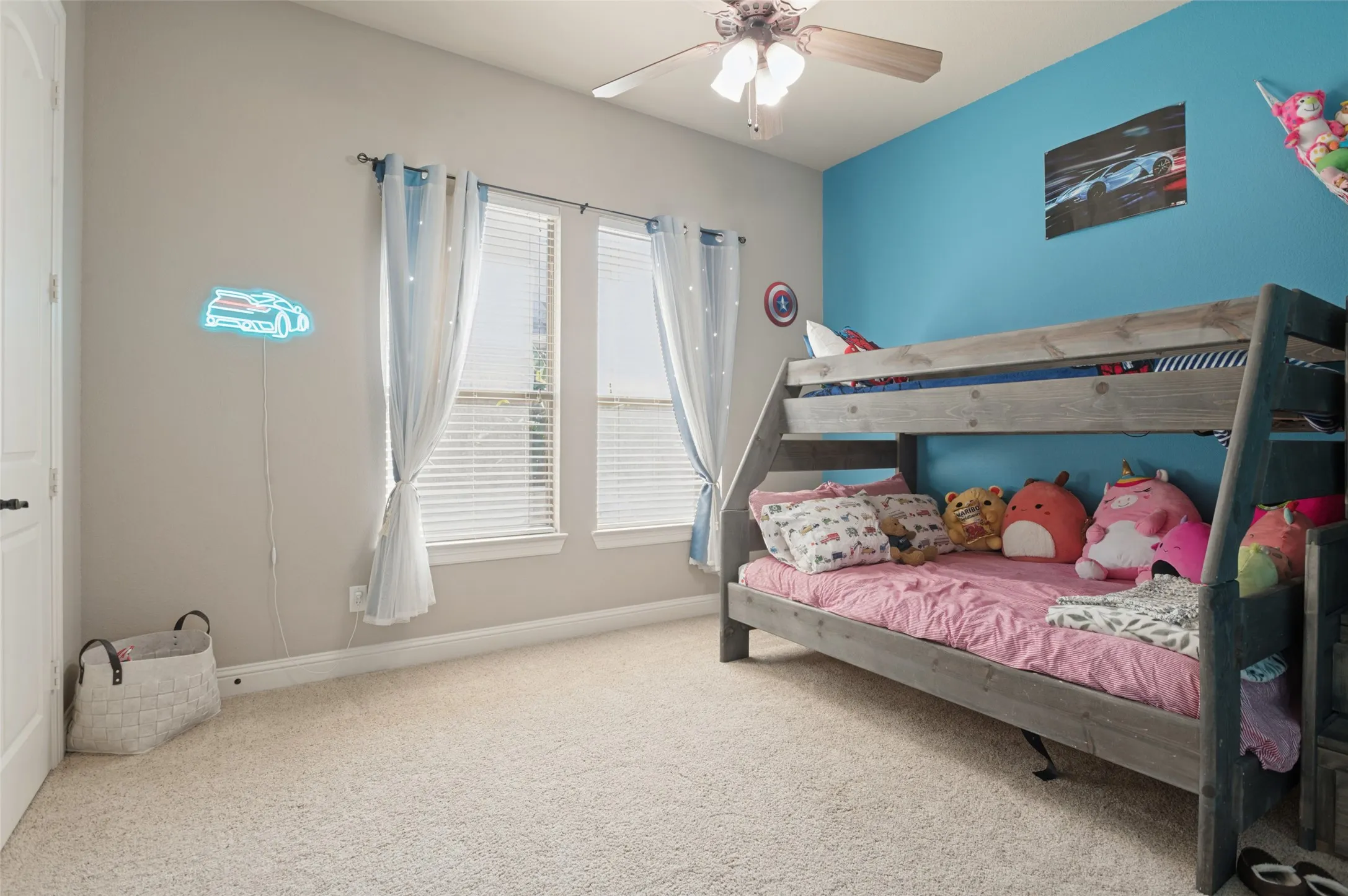 Carpeted flooring, two windows with blinds, ceiling fan with integrated lighting, two-tone wall paint
