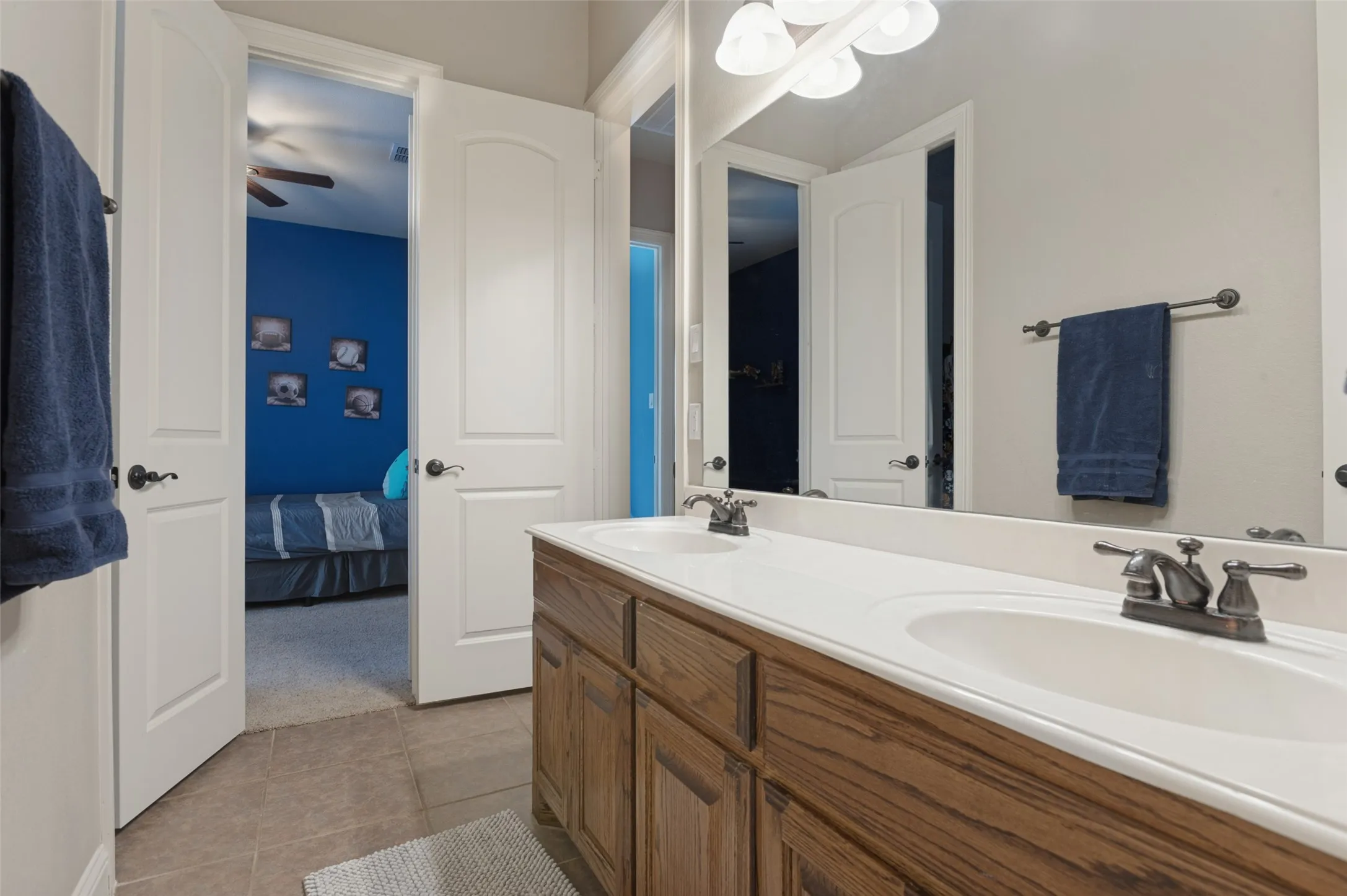 Double vanity with wood-finish cabinetry, dual undermount sinks, and bronze-finish faucets
