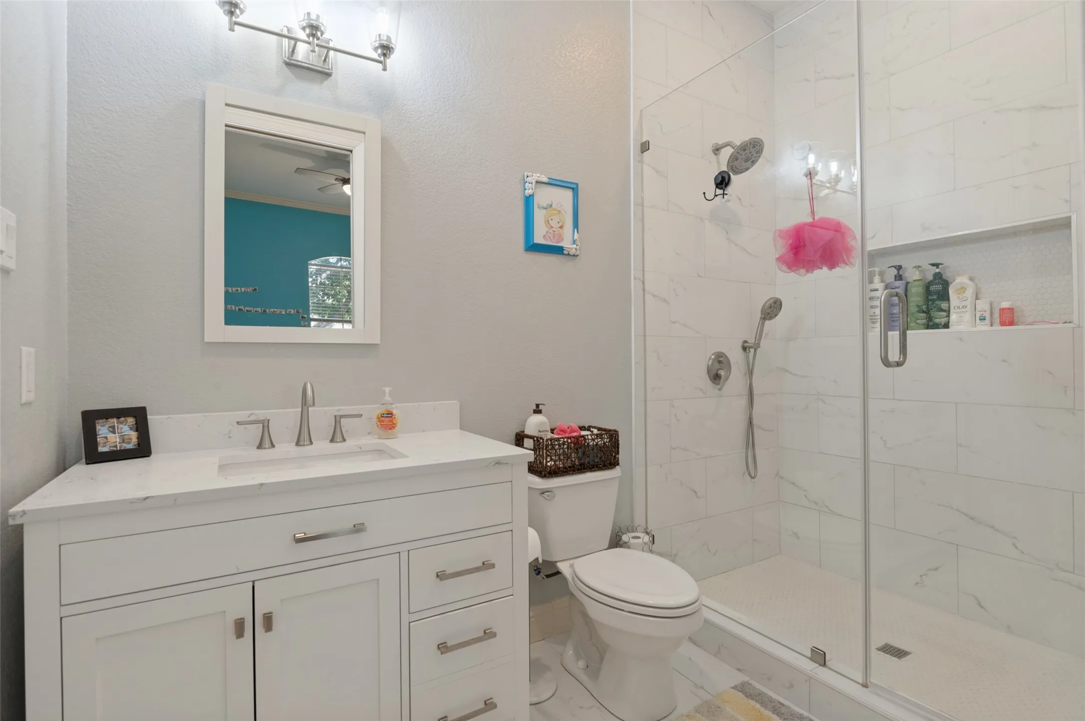 White vanity with brushed nickel hardware and a white countertop