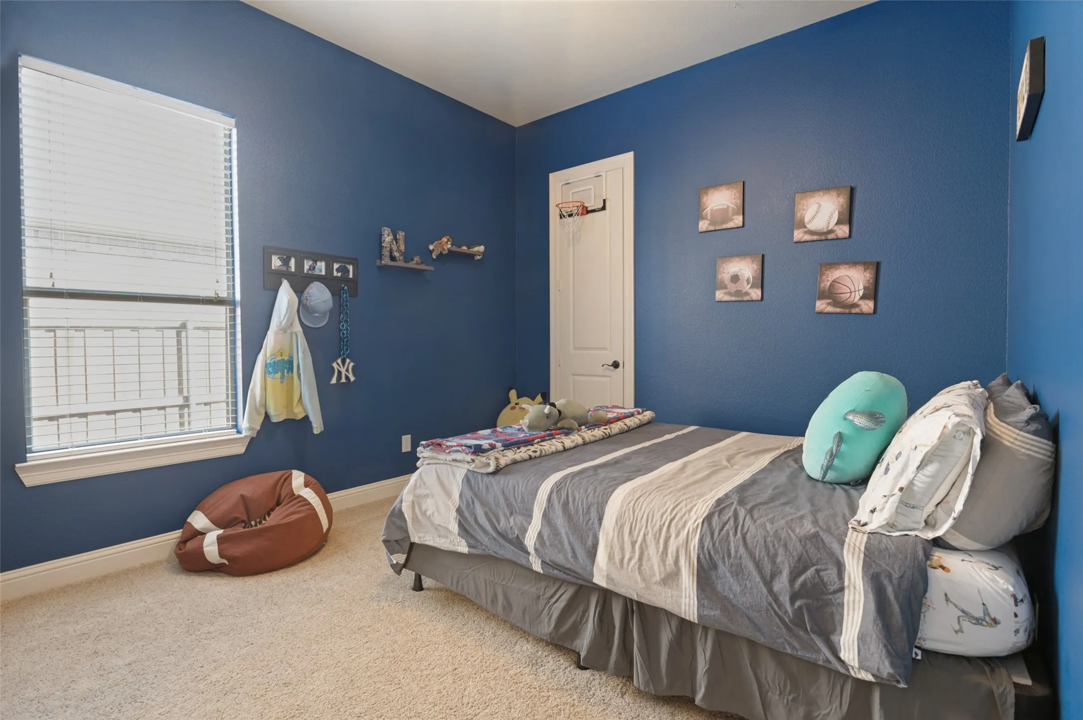 Carpeted room featuring a single window with blinds, white trim, and a built-in door